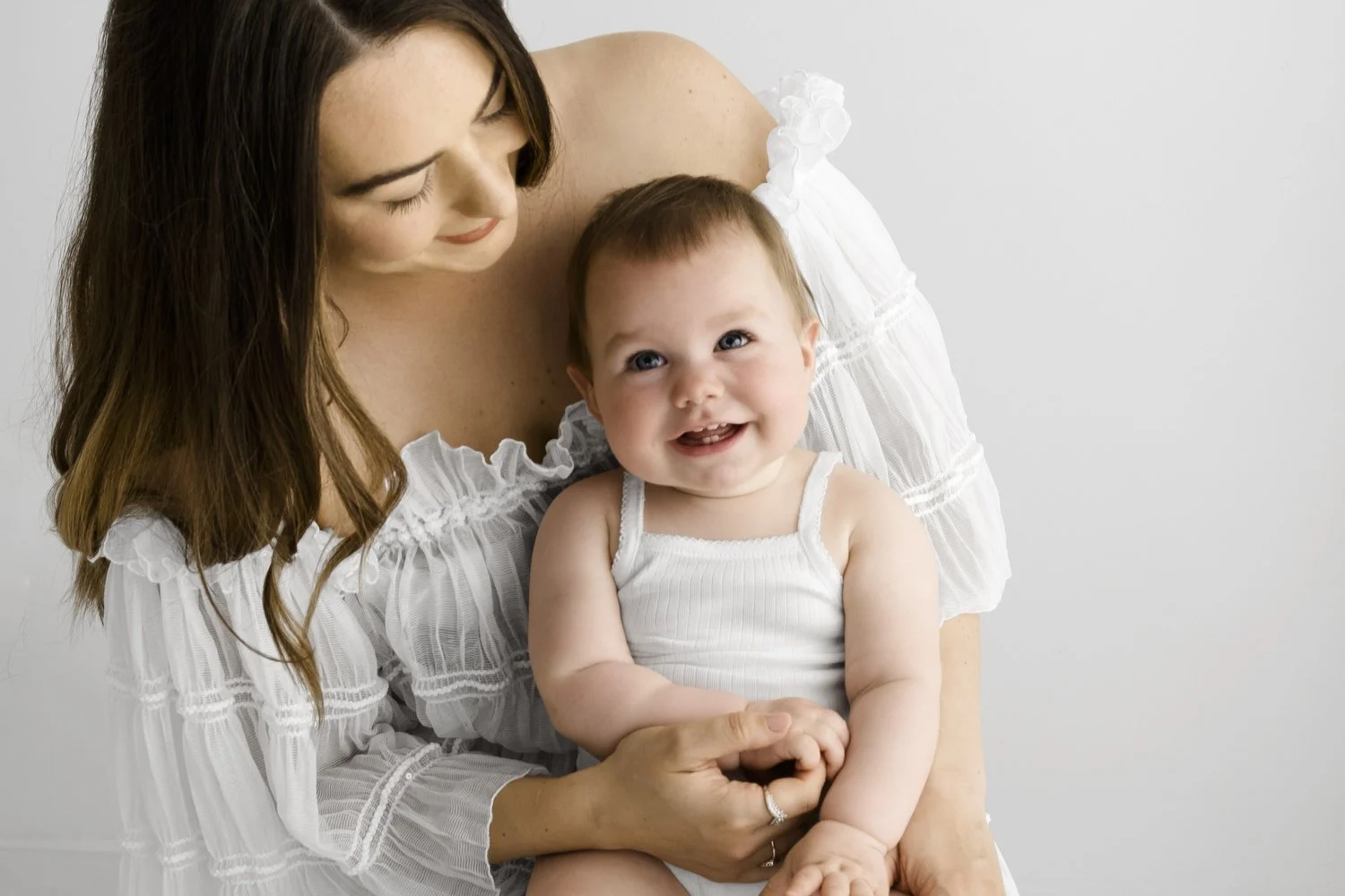 mum holding baby in Sleeveless white baby vest on newborn at Mabel and Moose photography studio Dundee