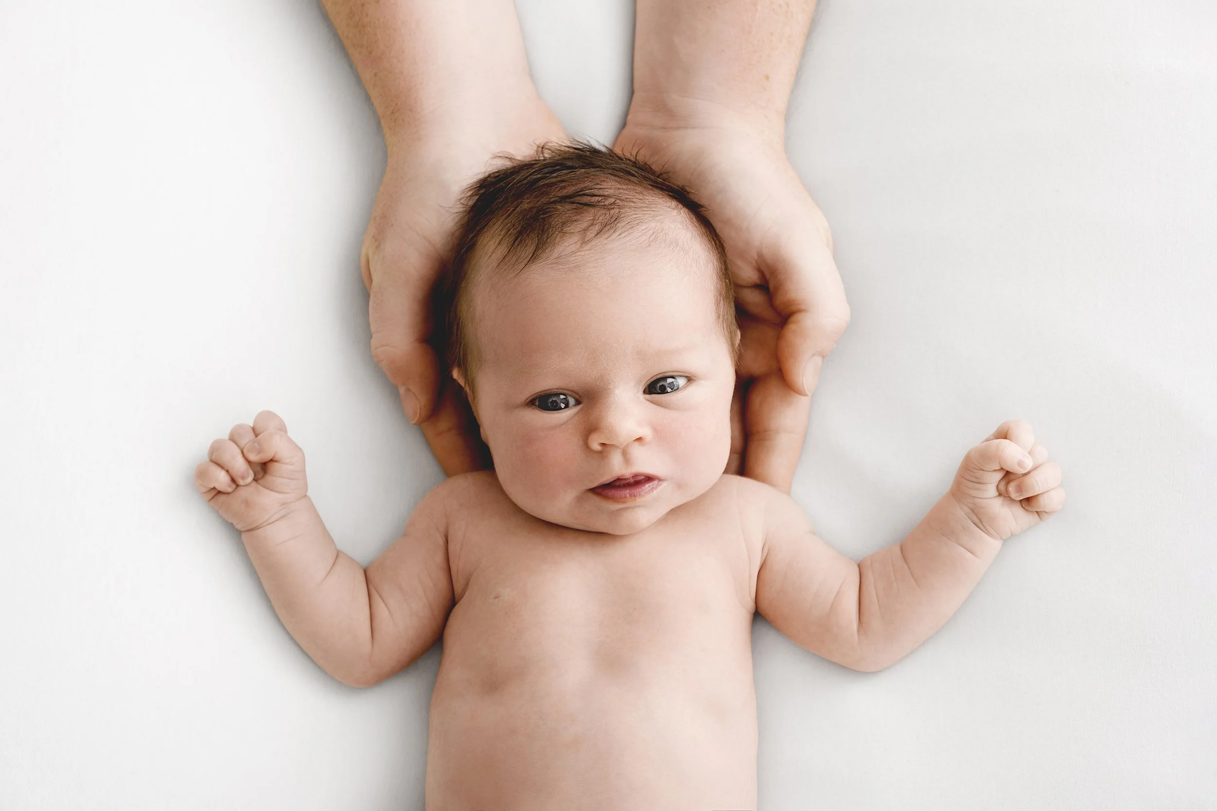 Awake 12 week old baby held in dad’s hands during Dundee studio photoshoot