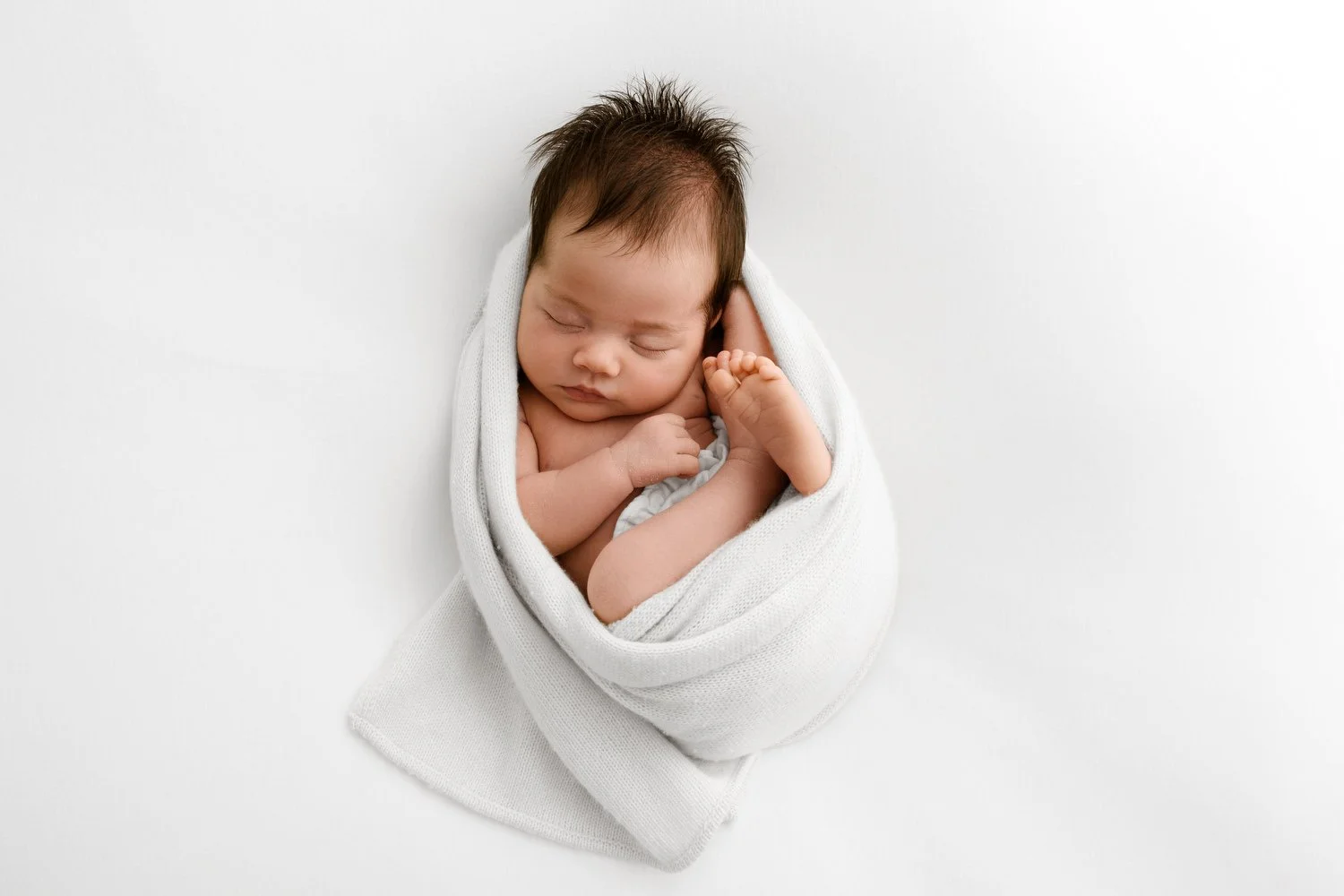 Baby on soft blankets, showing gentle, unhurried studio workflow for newborn sessions