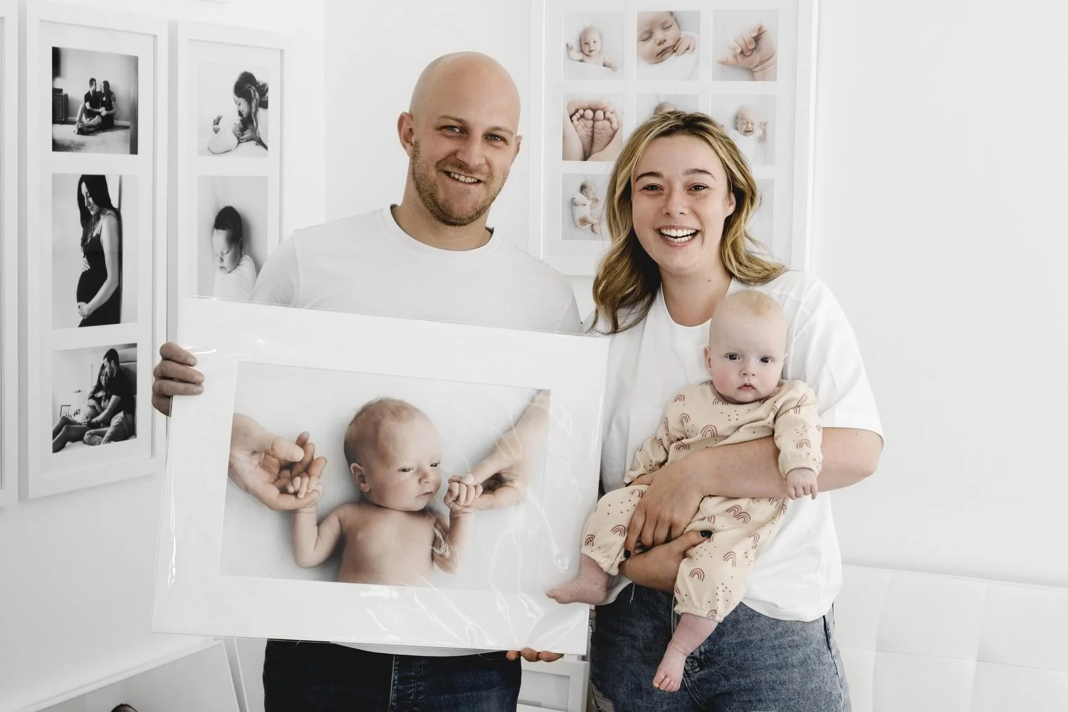 Parents holding their framed newborn wall portrait at Dundee studio