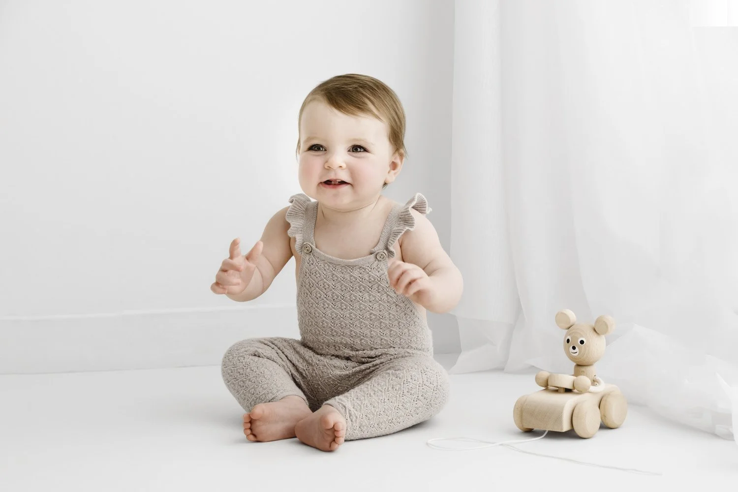9 month old baby sitting in natural studio setting