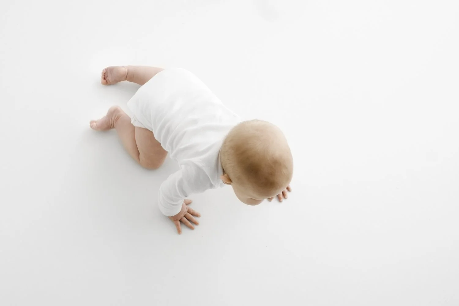 looking down on crawling 9 month old baby at natural studio photo session in dundee