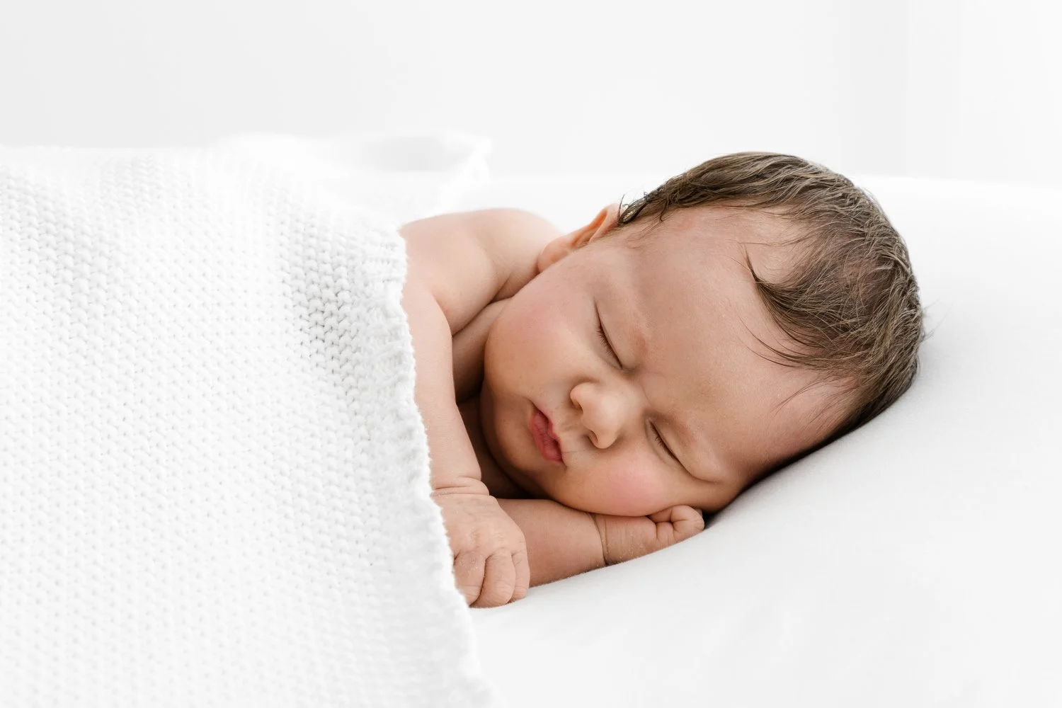 3 week old newborn sleeping on side under soft white blanket in Dundee studio