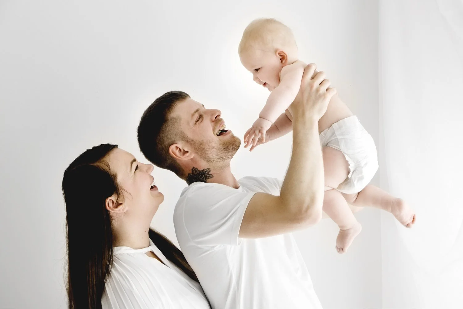Parents holding their 9 month old baby during family photoshoot in Dundee studio