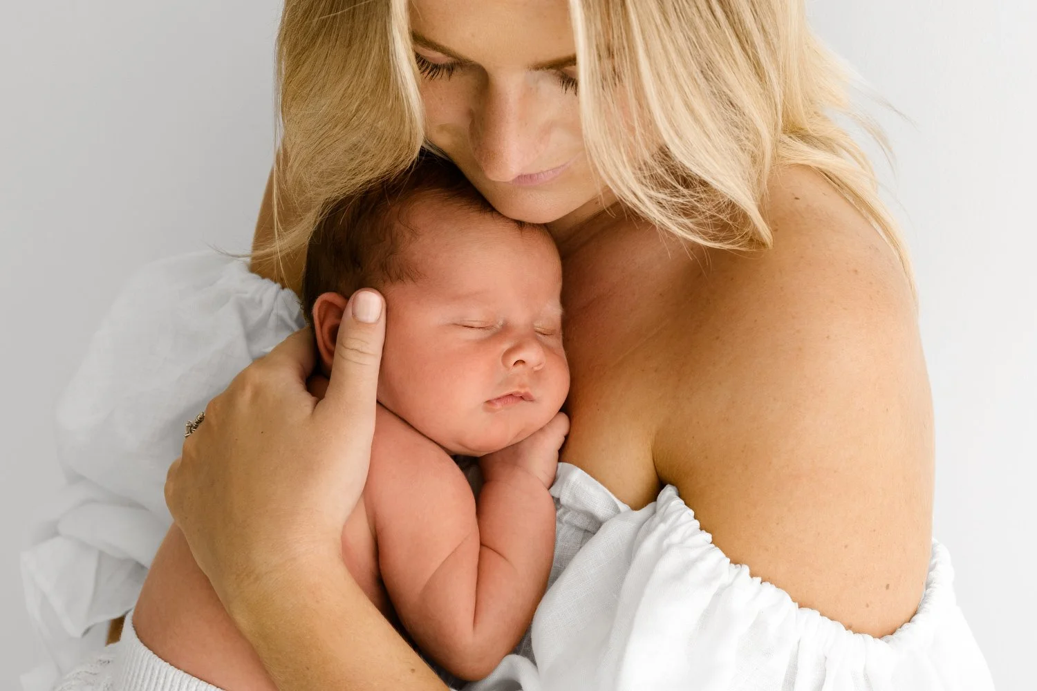 Mum cradling 14 day old newborn baby at Mabel and Moose studio Monifieth Dundee