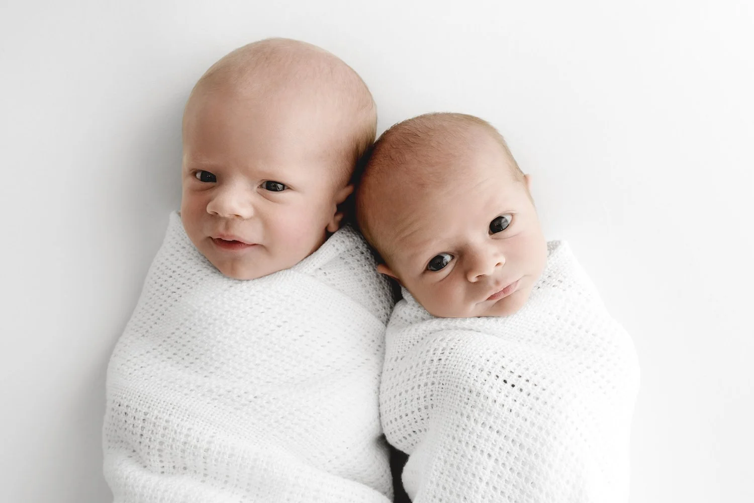 awake Newborn twin babies lying together at Mabel and Moose studio Dundee