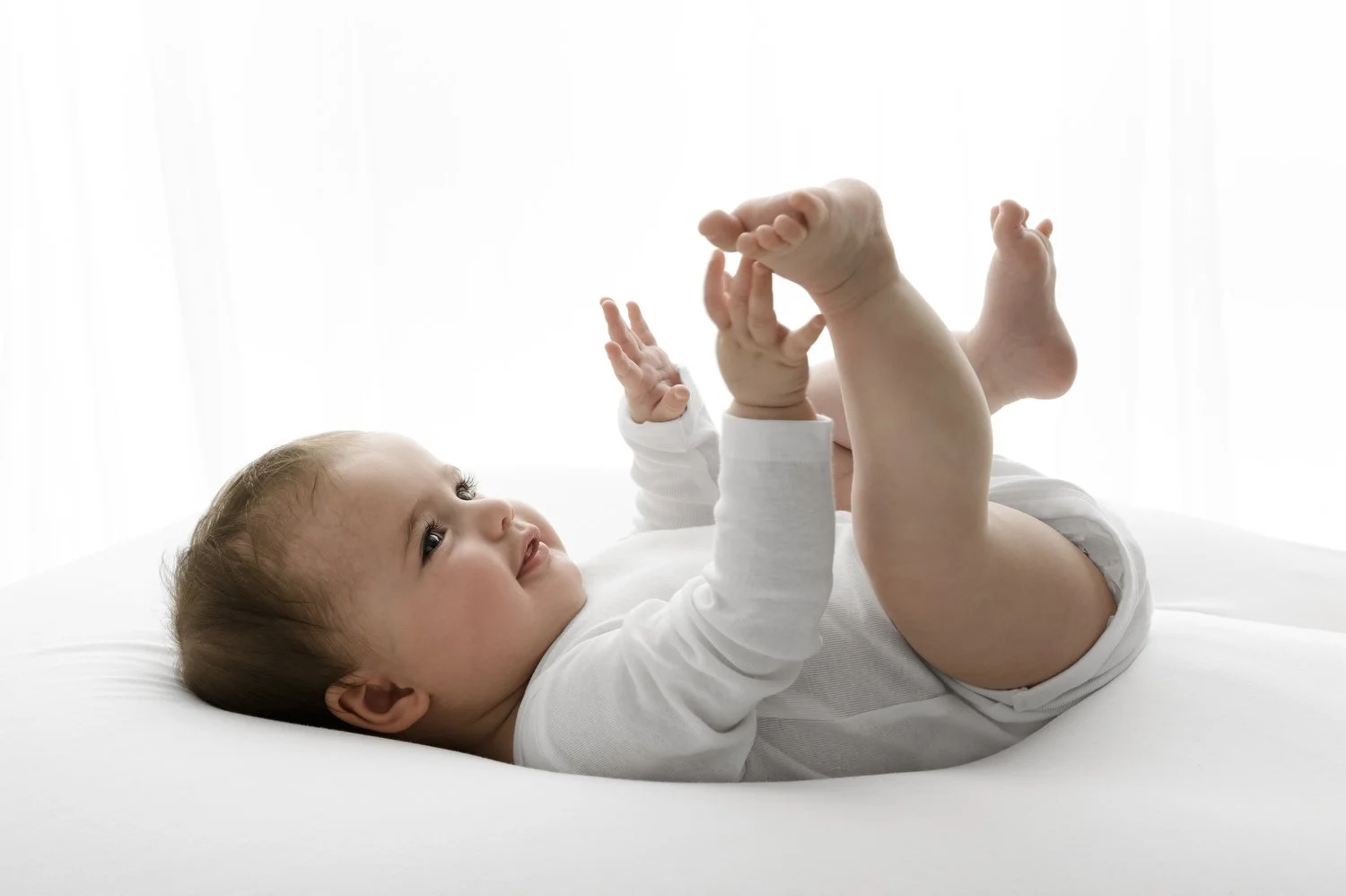 baby playing with it's toes at Natural prop free baby photography at Mabel and Moose studio Monifieth Dundee