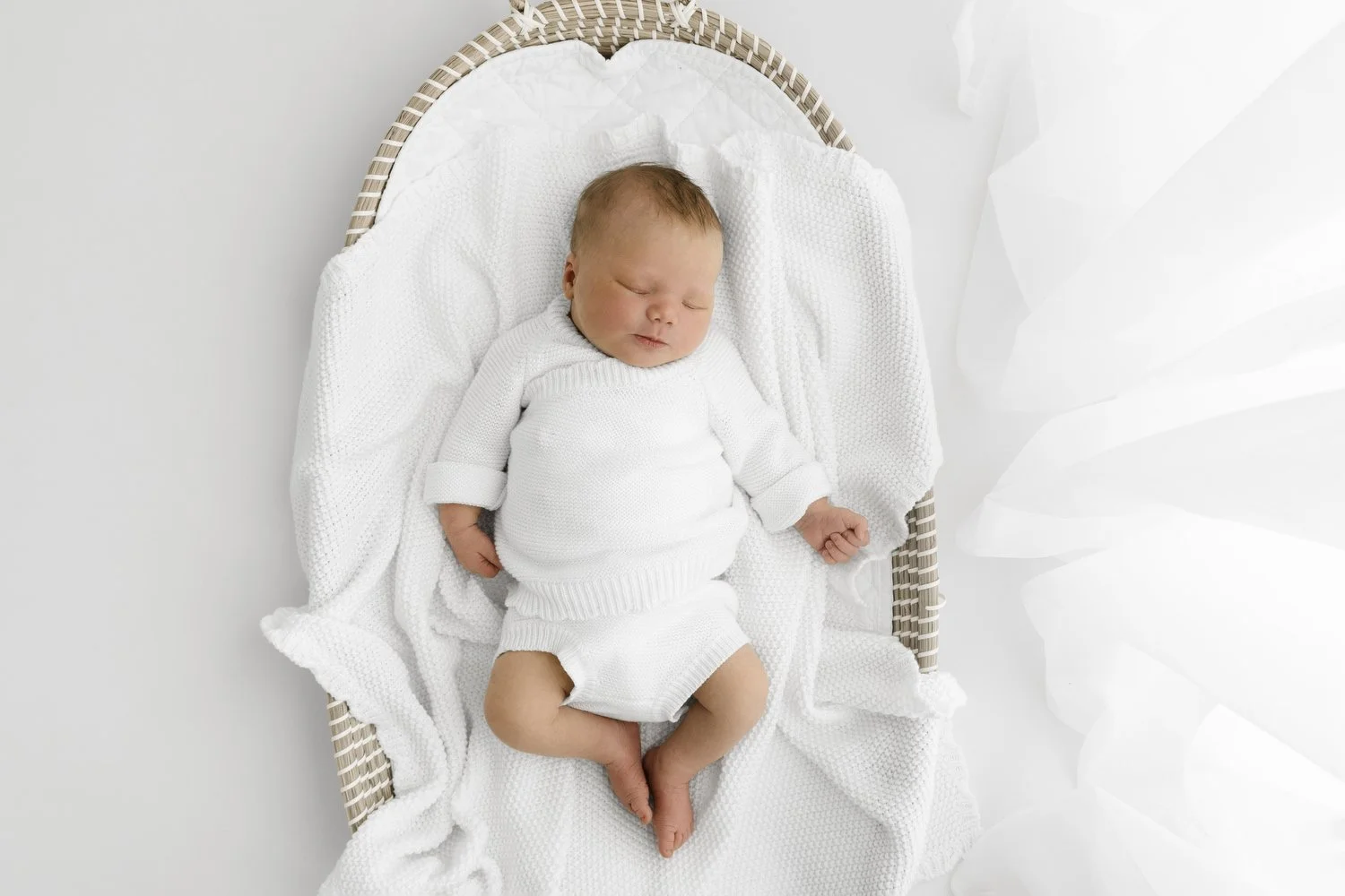 sleeping newborn baby in natural seagrass basket at Mabel and Møøse newborn photography studio Dundee