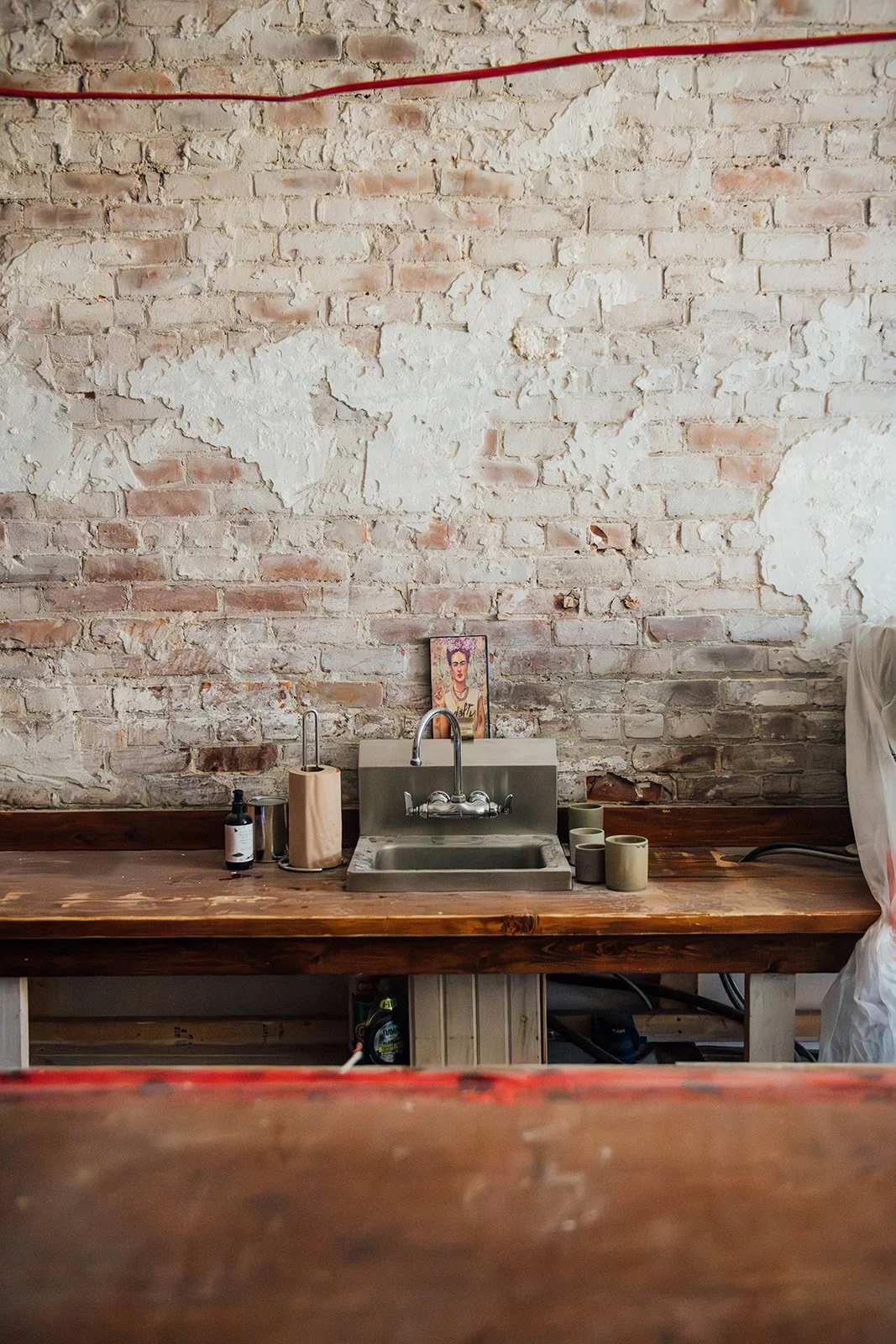  The whitewashed brick wall, a remnant of the space's past life, would go on to become a defining focal point behind the bar. 