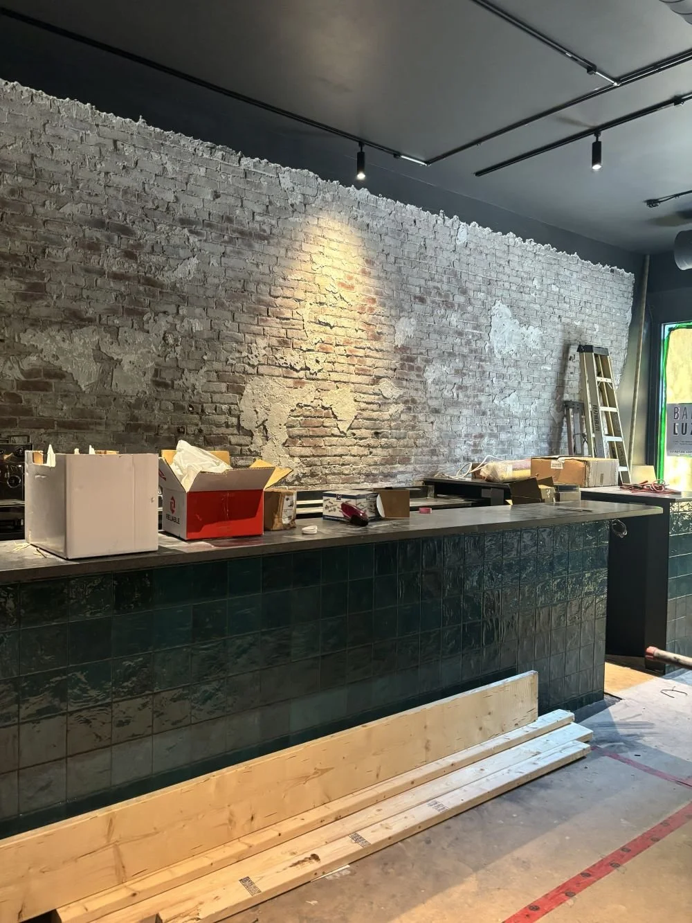  The teal bar tiles begin to emerge alongside the dramatic off-black ceiling. 