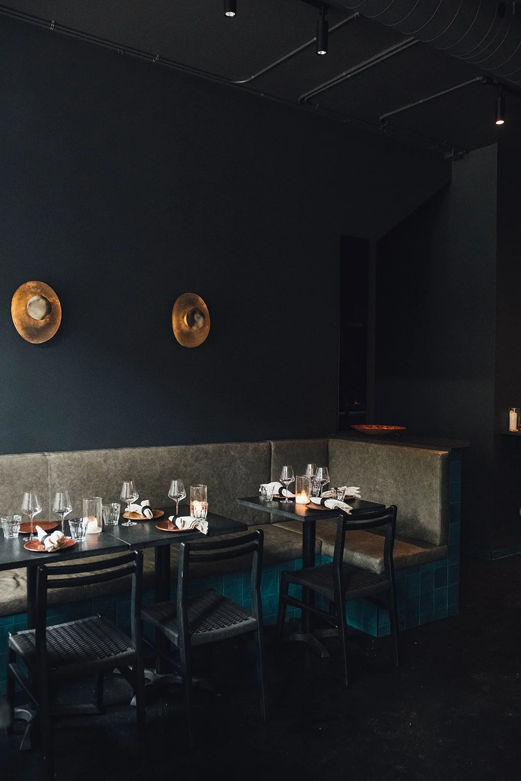  The custom ceramic sconces by Atelier Fromenta and ceramicist Emmanuelle Rocque cast warm, shifting light above the banquette, each one entirely unique in shape, texture, and colour. 