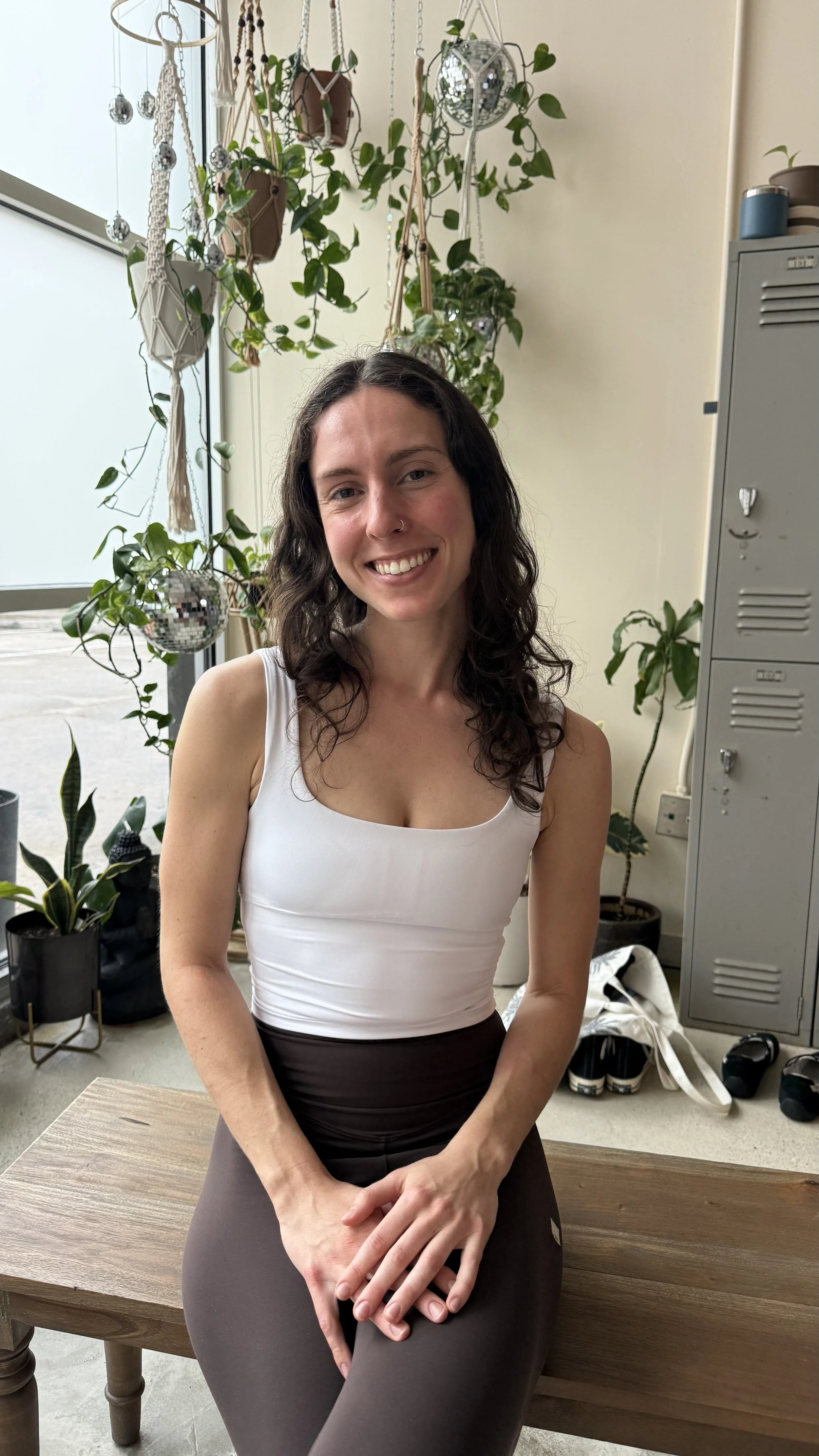 Group of people practicing yoga in a studio with exposed brick walls and wooden floors.