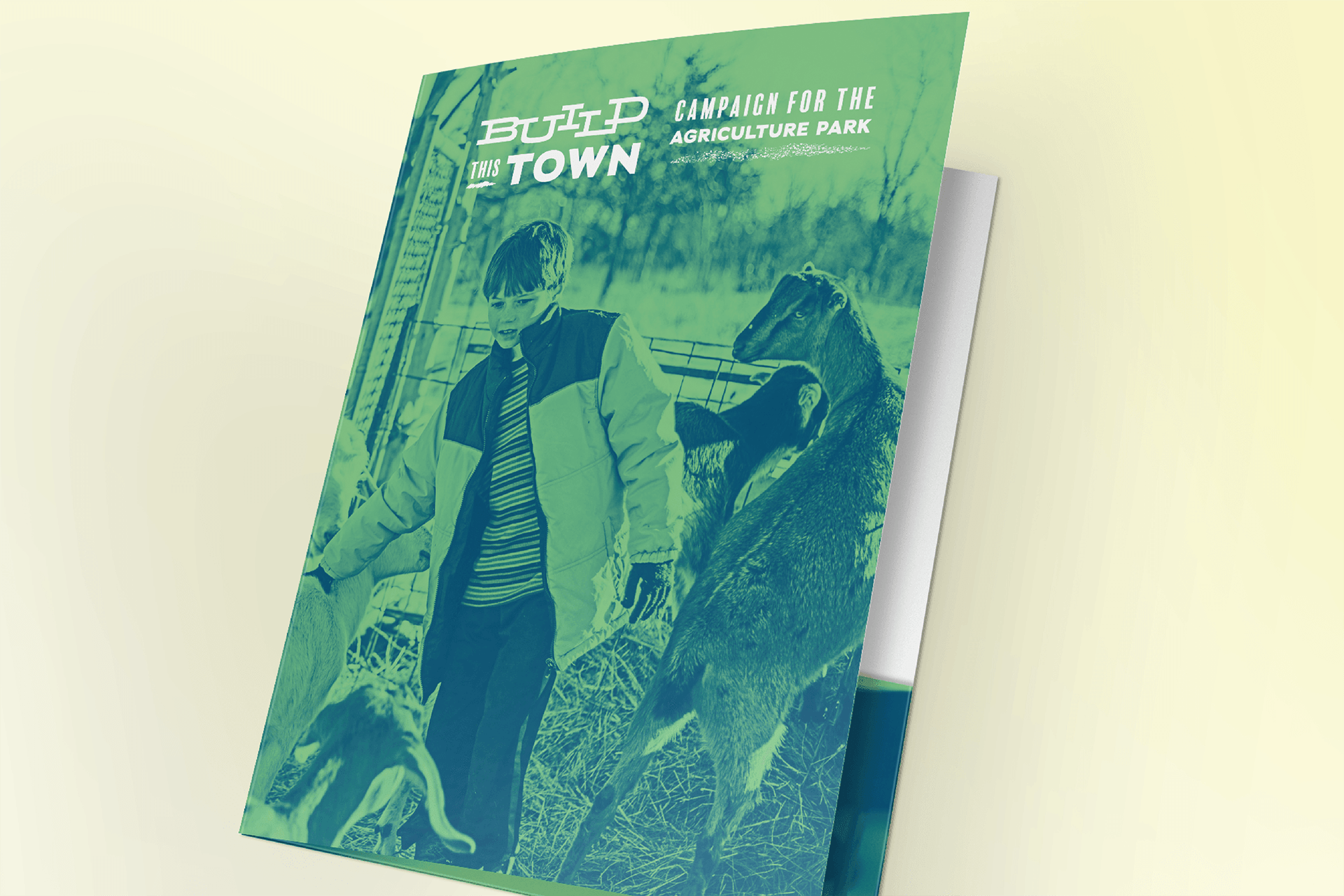 Folder design for Build This Town fundraising campaign. Photo of young boy around farm animals on cover.