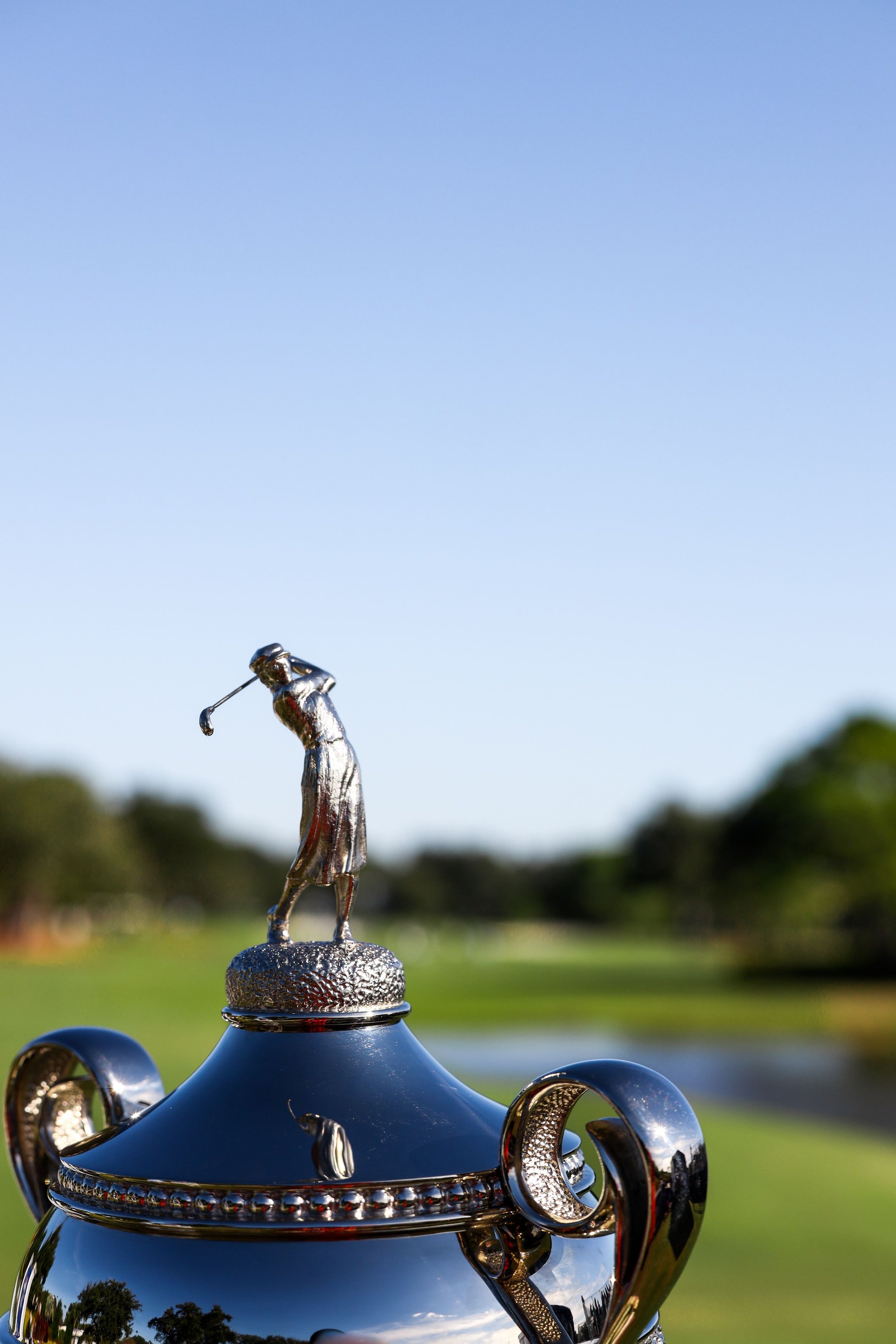  Close-up of golf athlete figure on top of silver trophy branded event photography. 