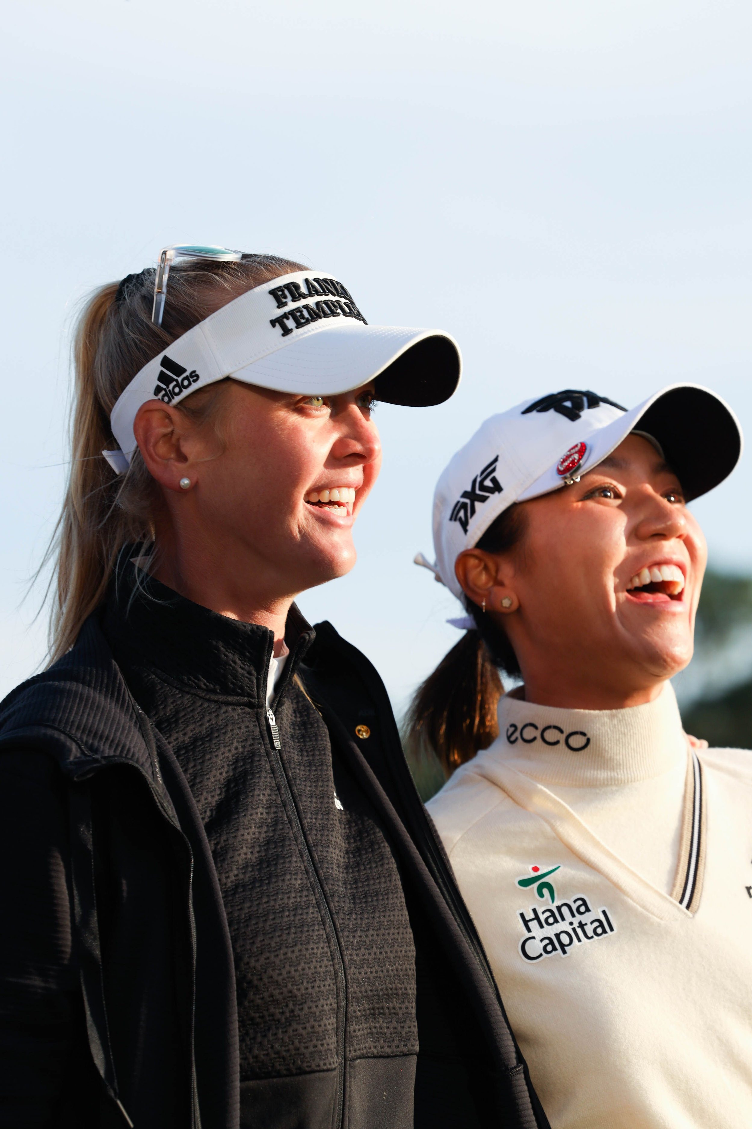  Female golf athletes smiling while reacting to tournament branded event photography. 