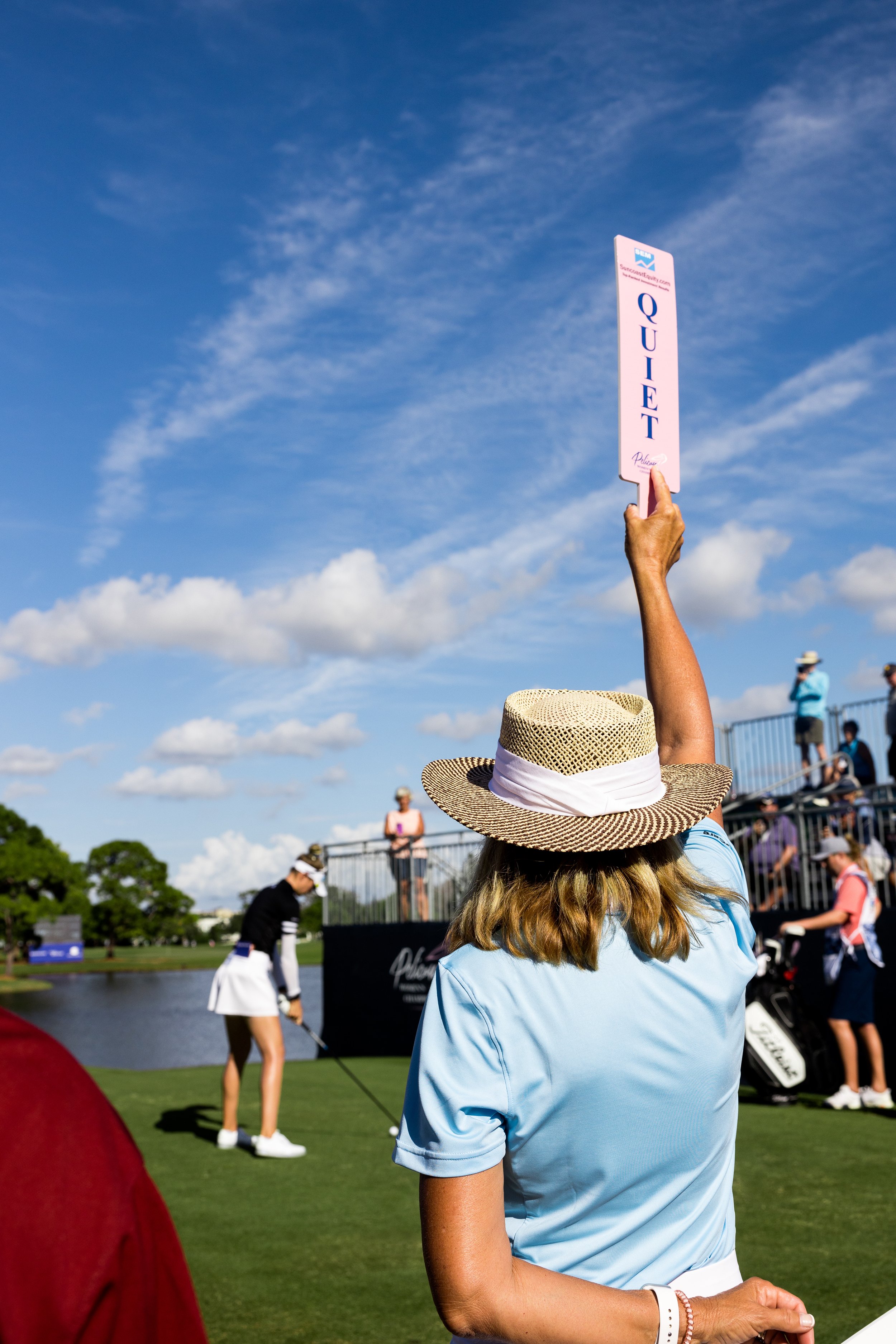  Person holding up “quiet” sign during golf tournament. 