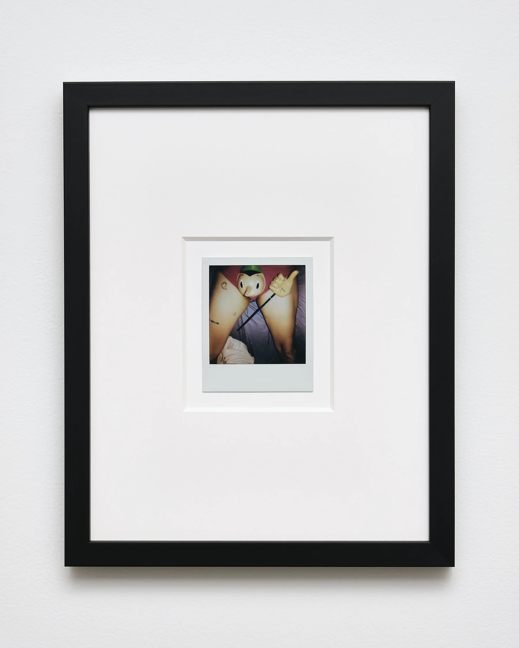 Framed photo of Pinocchio with a pointing hand, resting on the person's lap.