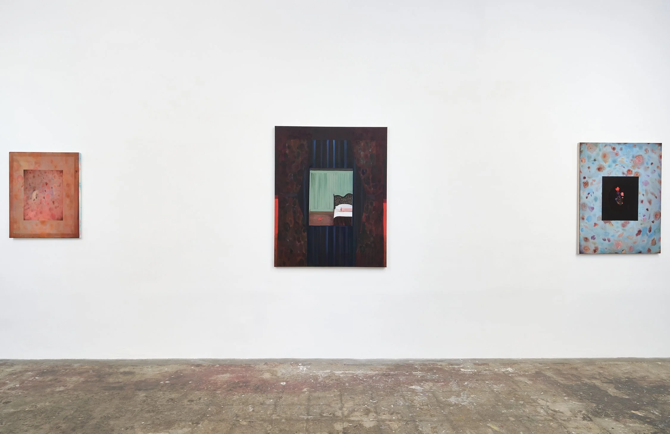 Three abstract paintings displayed on a white gallery wall with a wooden floor.