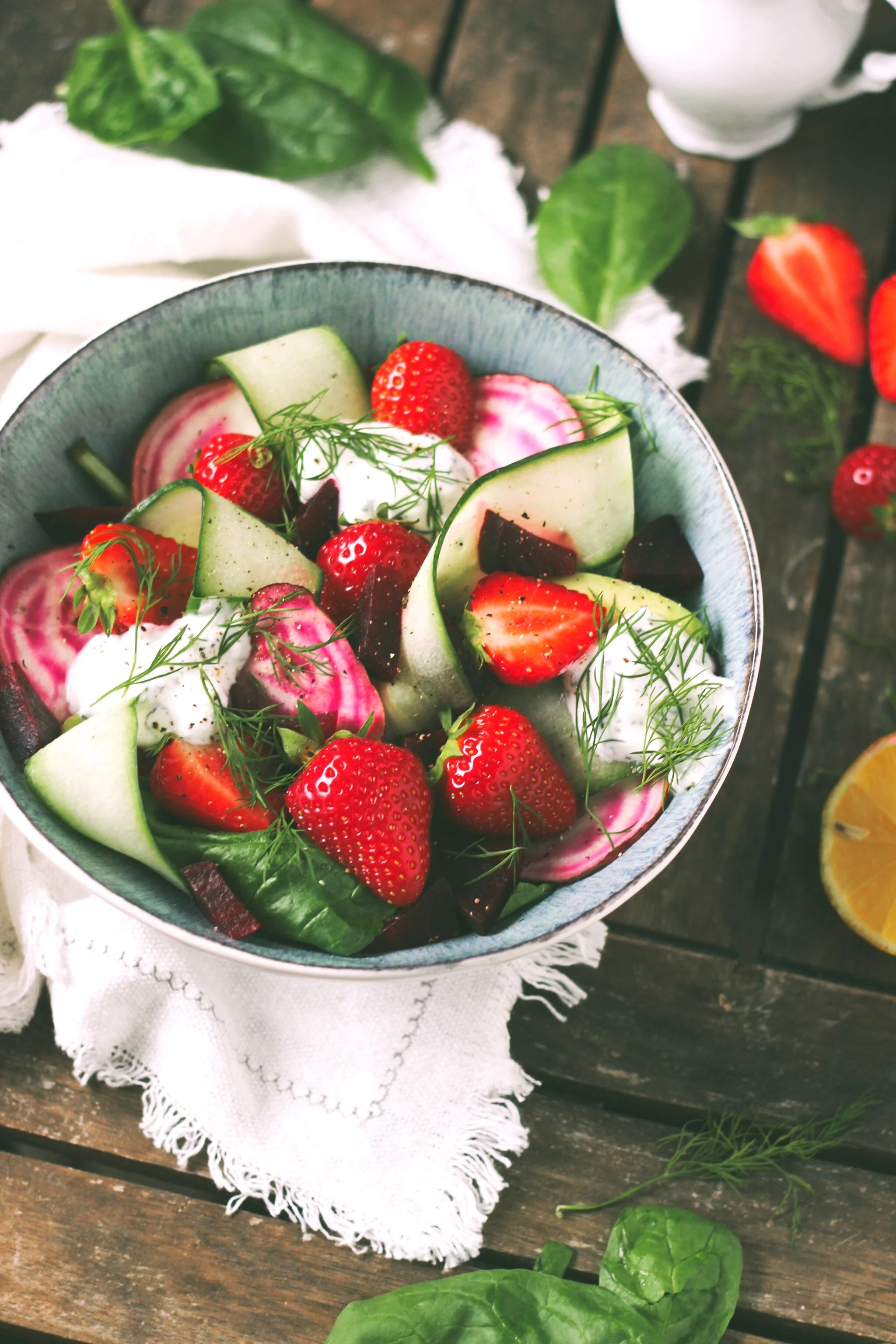 Zomerse salade met spinazie, komkommer, chioggia biet, avocado, aardbeien en een yoghurt munt saus