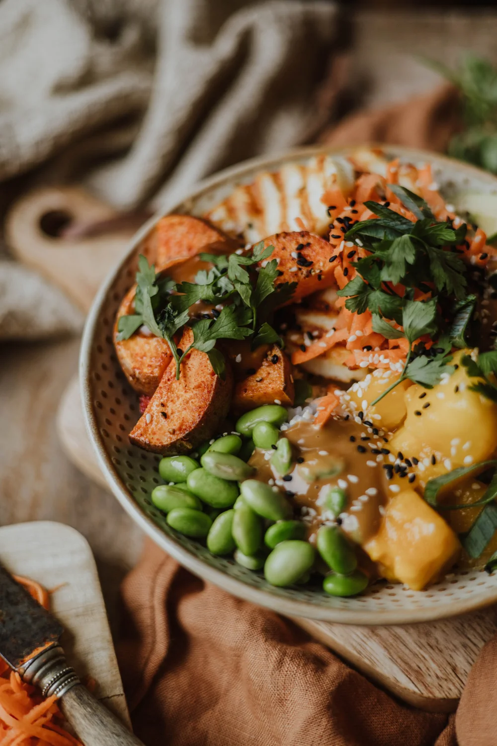 Poke bowl met halloumi, zoete aardappel, mango, avocado en een zoete