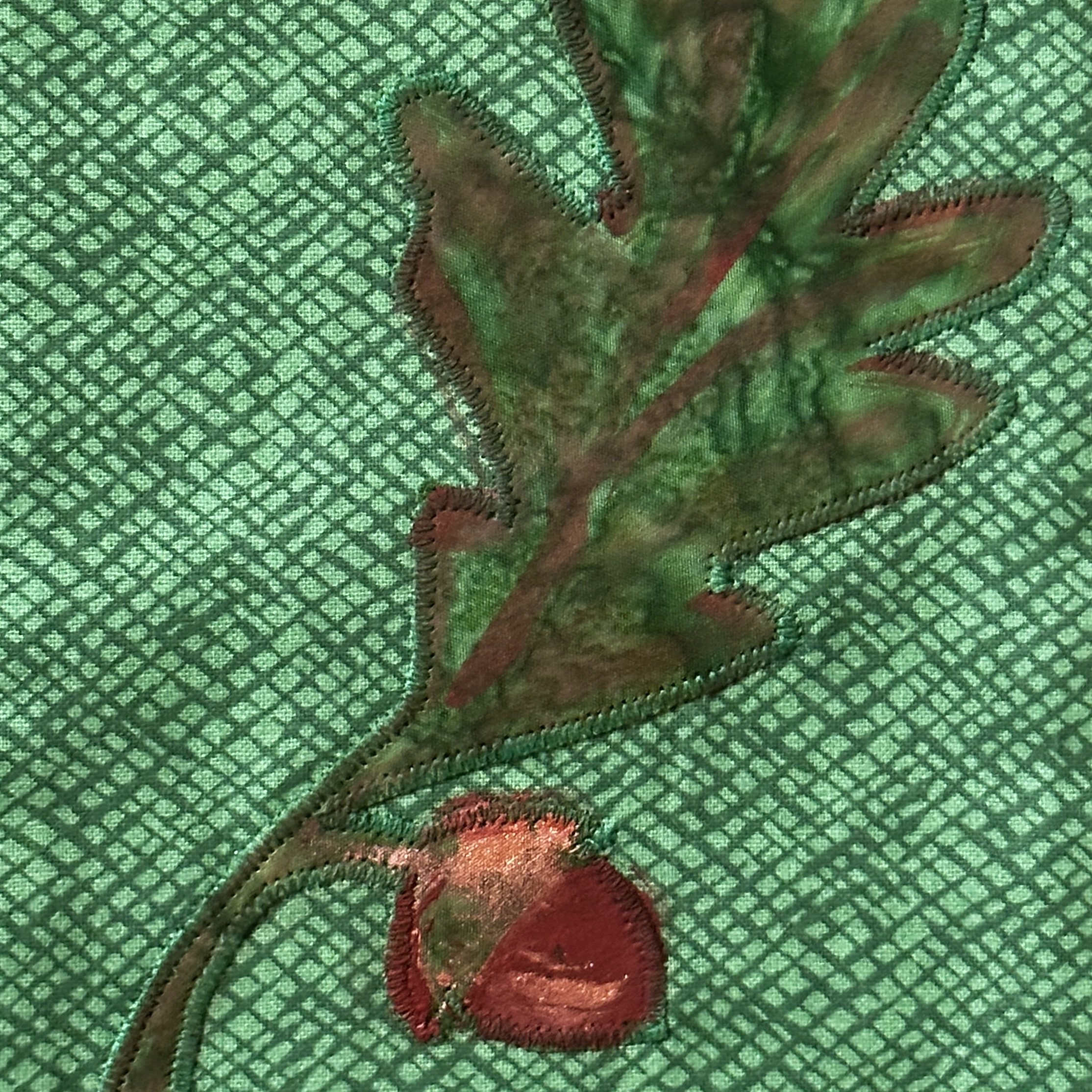 Detail of painted oak leaf on a handmade green clergy stole.