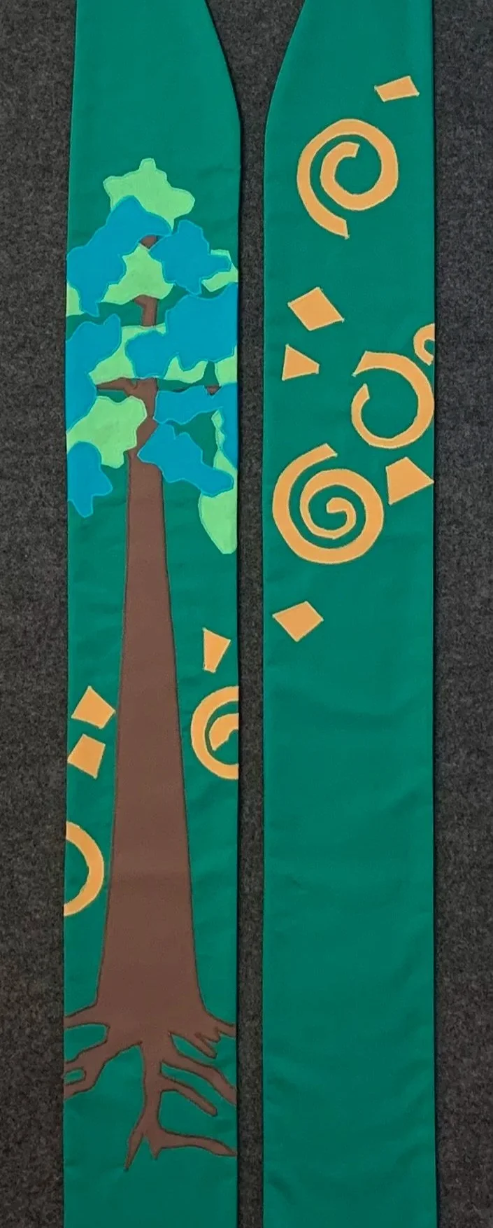 A custom commissioned stole by Carrot Top Studio that is green with a tree and spirals.