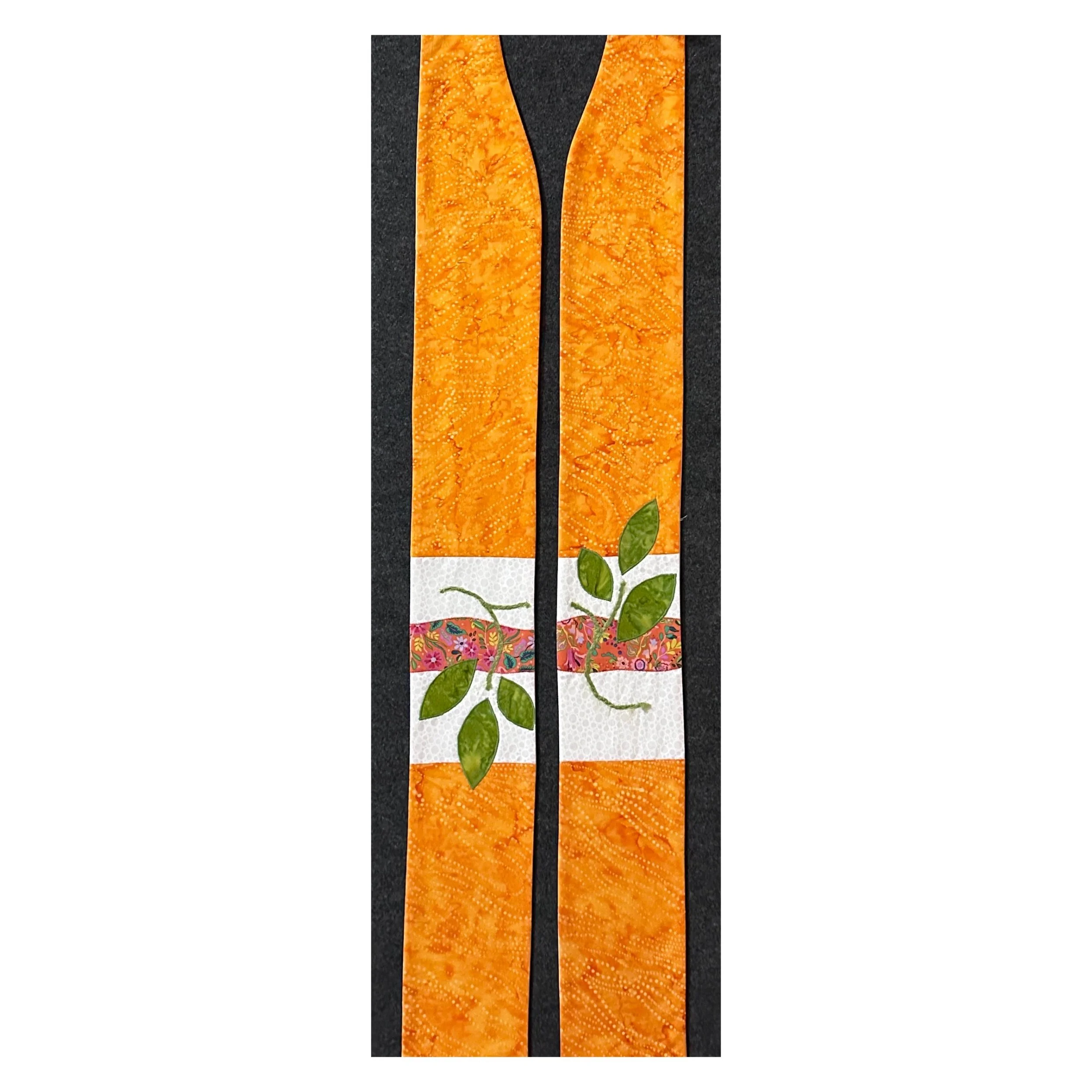 Orange clergy stole with white border, whimsical plant accents, and appliquéd leaves—symbolizing growth, healing, and God’s renewing peace. Shop stoles at Carrot Top Studio.