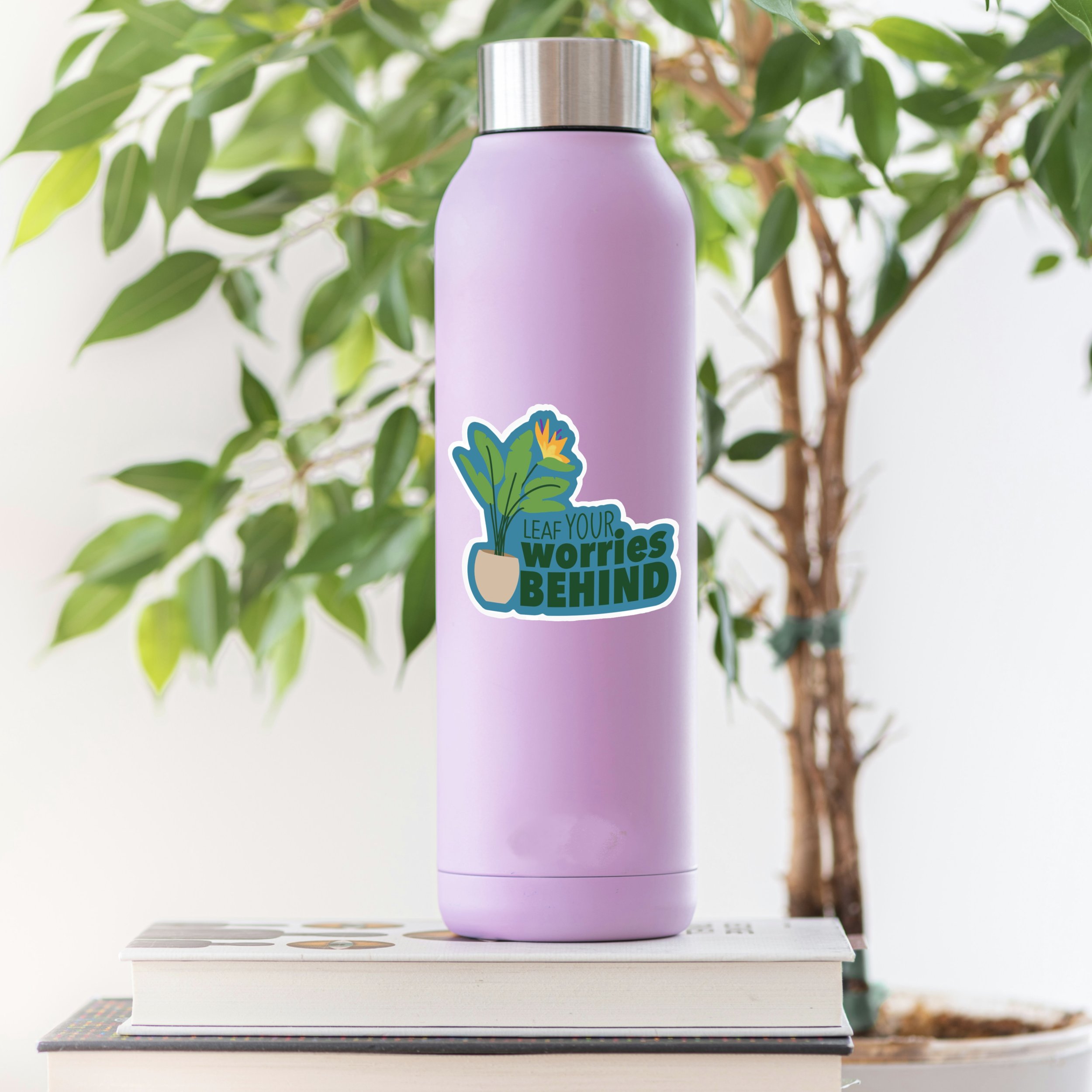 The 'Leaf Your Worries Behind' pun plant sticker on a water bottle from the Carrot Top Studio sticker shop.