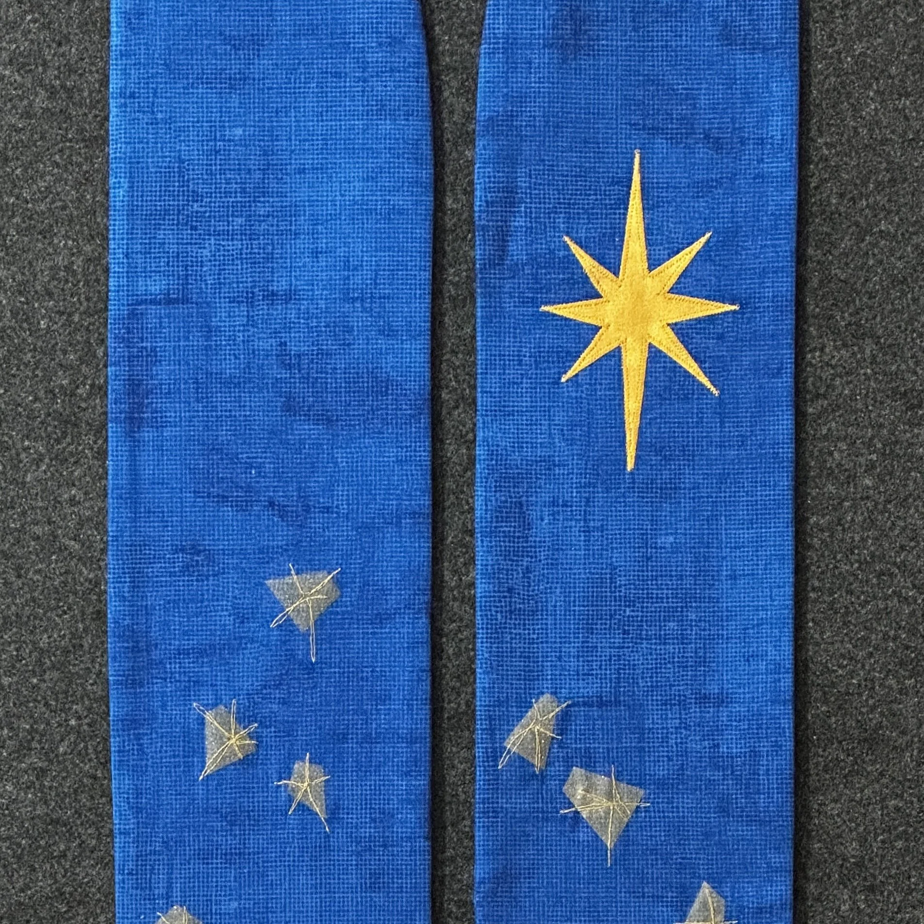A detail with the star of Bethlehem on a blue clergy Advent stole.