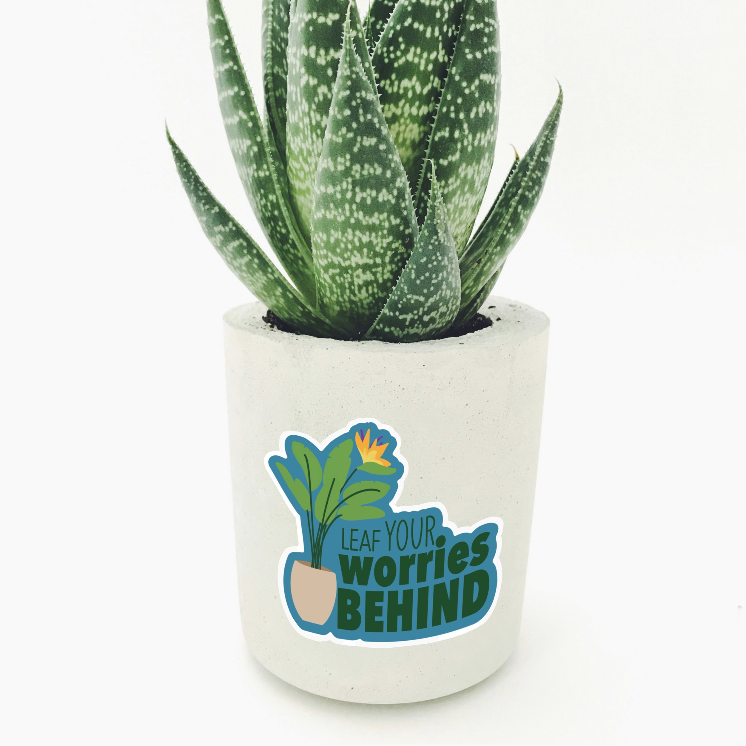 The 'Leaf Your Worries Behind' pun plant sticker on a plant pot from the Carrot Top Studio sticker shop.