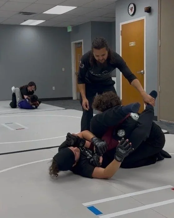 Self-defense training for teens. Teens practicing grappling techniques on mats in a room, overseen by instructors at Shaan Saar Krav Maga.