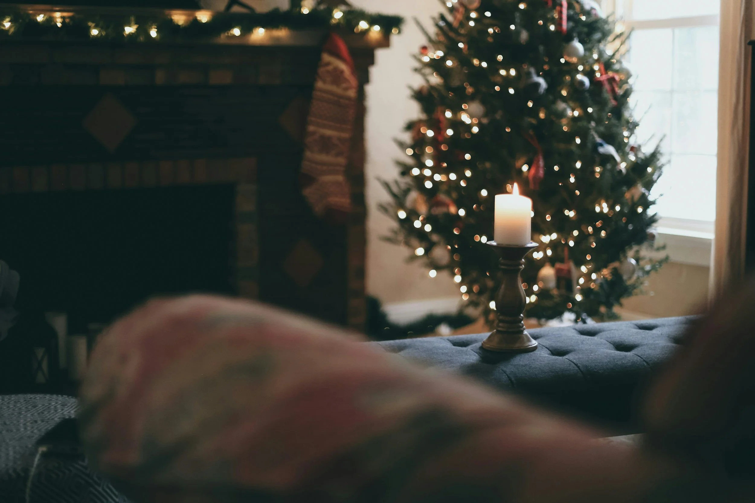 a lit candle on an blue ottoman, in a room with beautiful christmas decorations, therapy for overstimulated moms in colorado