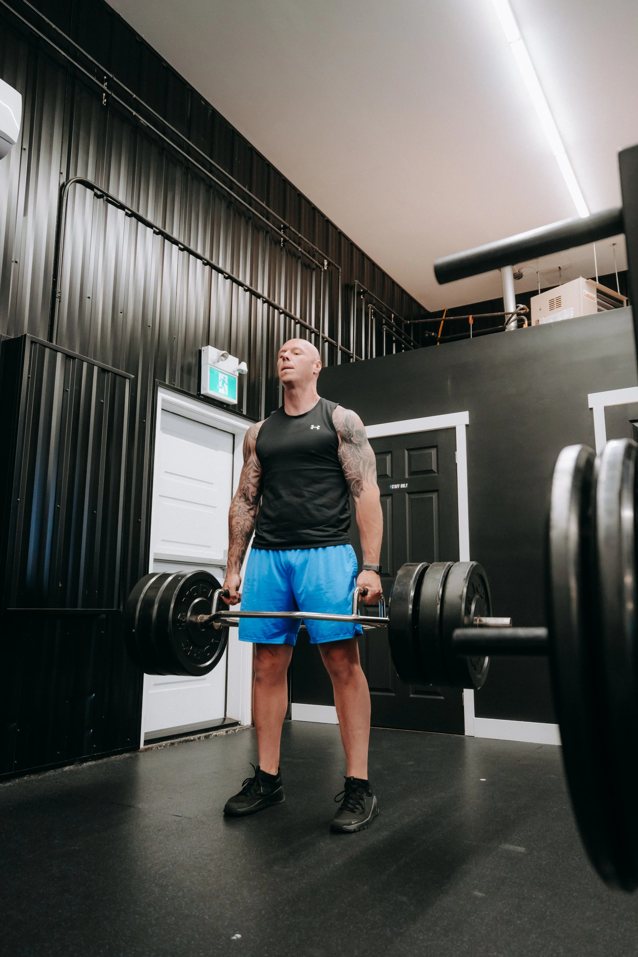 Coach Charlie lifting a loaded trap bar deadlift at Jolt Fitness