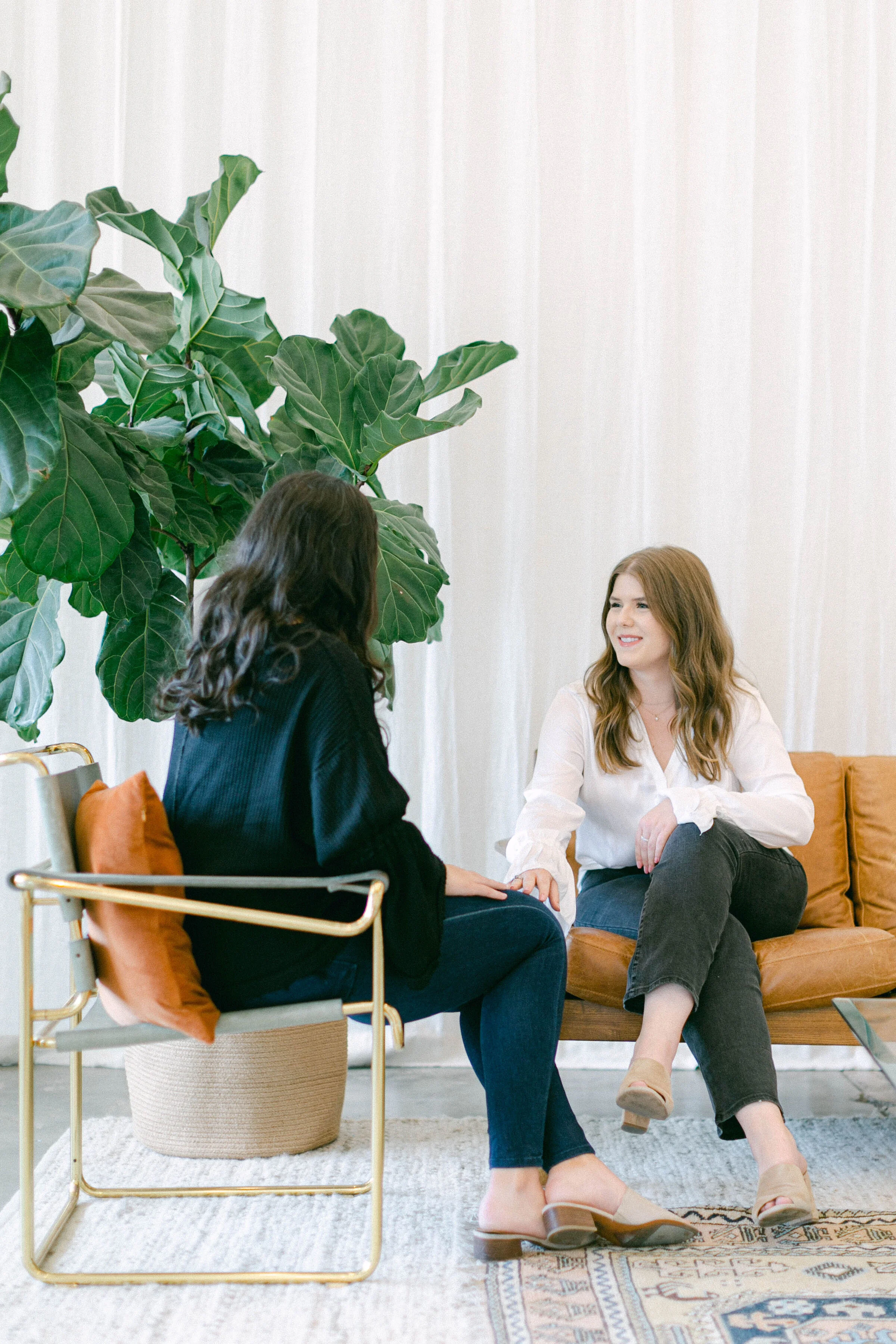 Chadley Zobolas sitting across from a client, offering a compassionate and supportive presence during a therapy session in his Denver office.