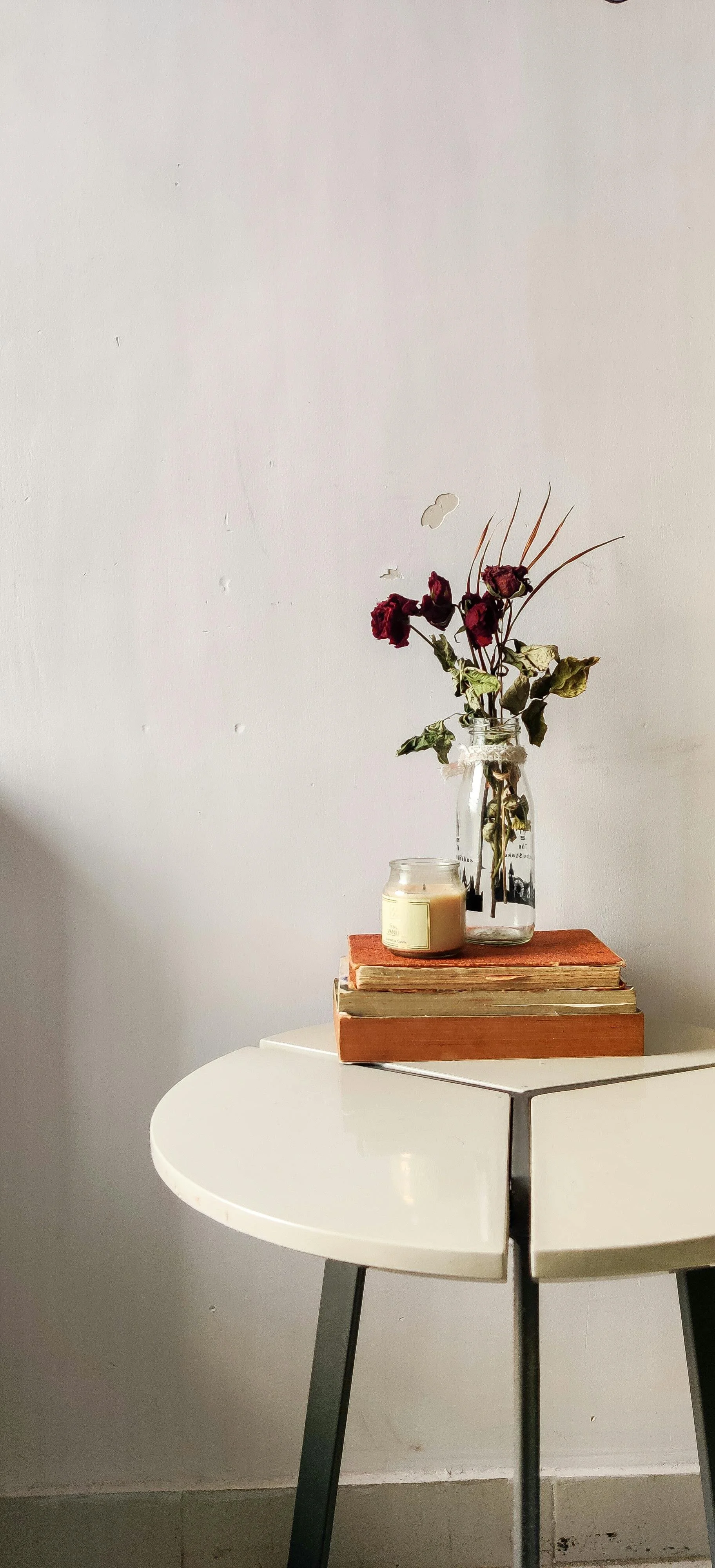A vase of roses sitting on a stack of books, providing a soft and comforting atmosphere in our Denver anxiety counseling office.