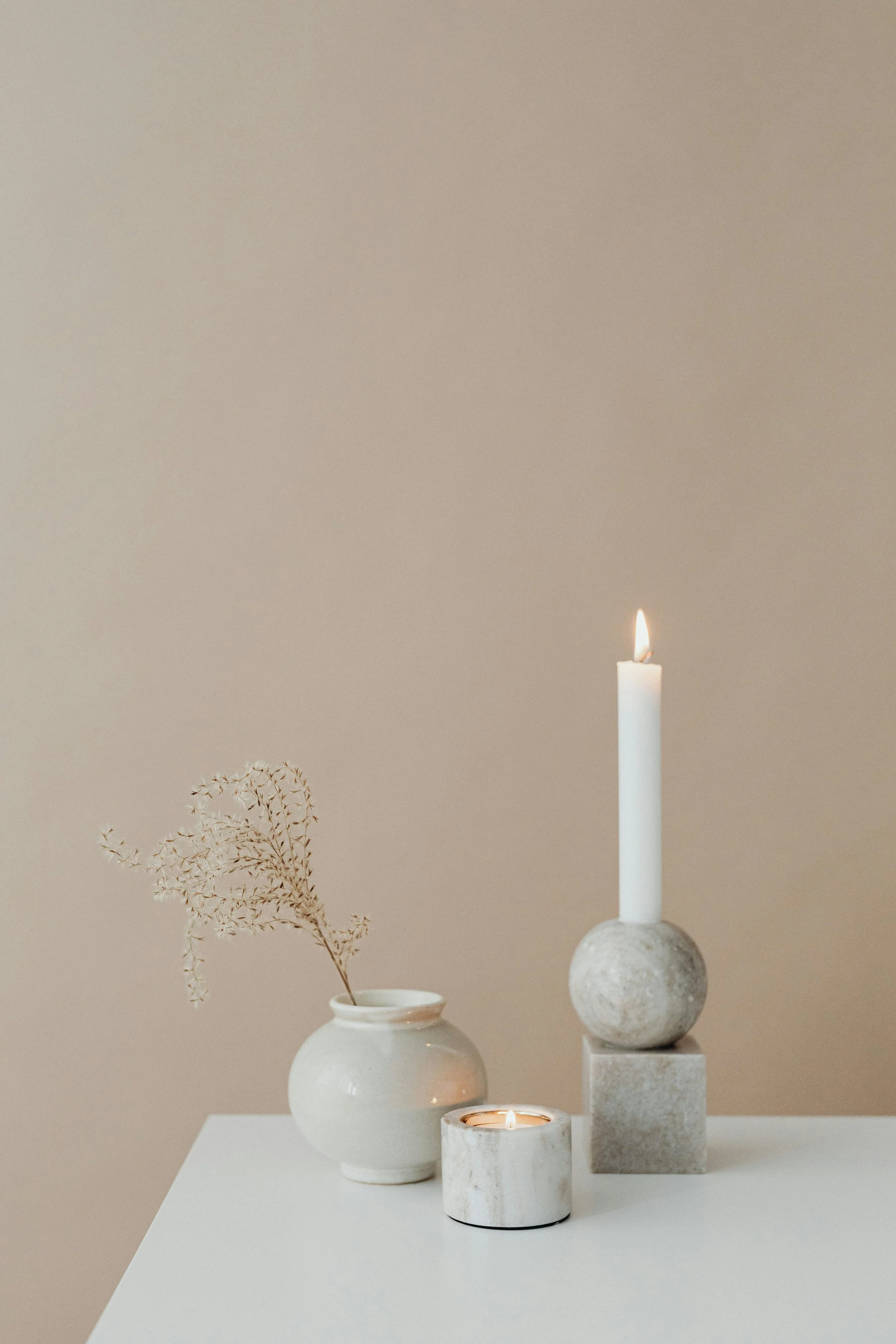 Two candles at varying heights in a marble holder, creating a meditative and focused environment for counseling in our Denver office.