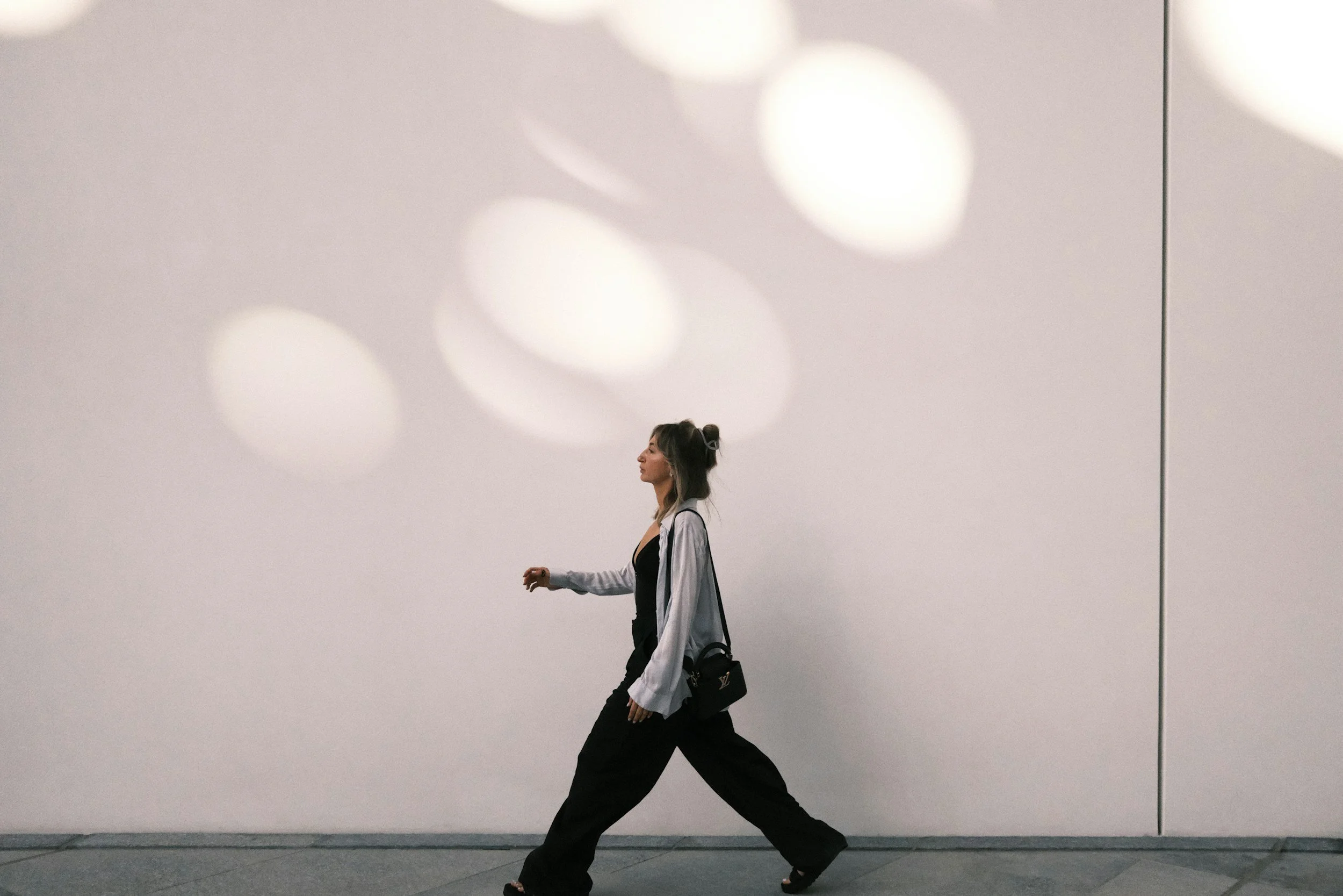 Woman walking forward confidently representing authenticity and breaking free from people-pleasing patterns