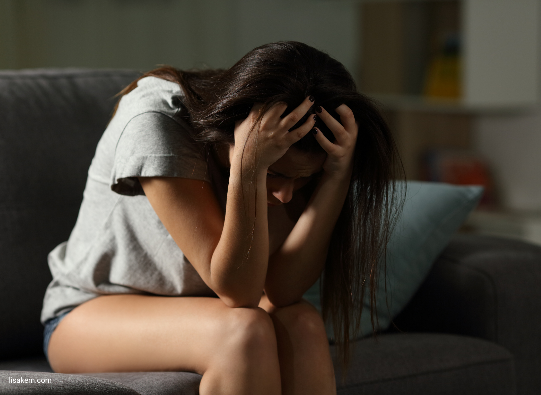 Woman holding her head in overwhelm, representing the confusion between anxiety and a spiritual awakening.
