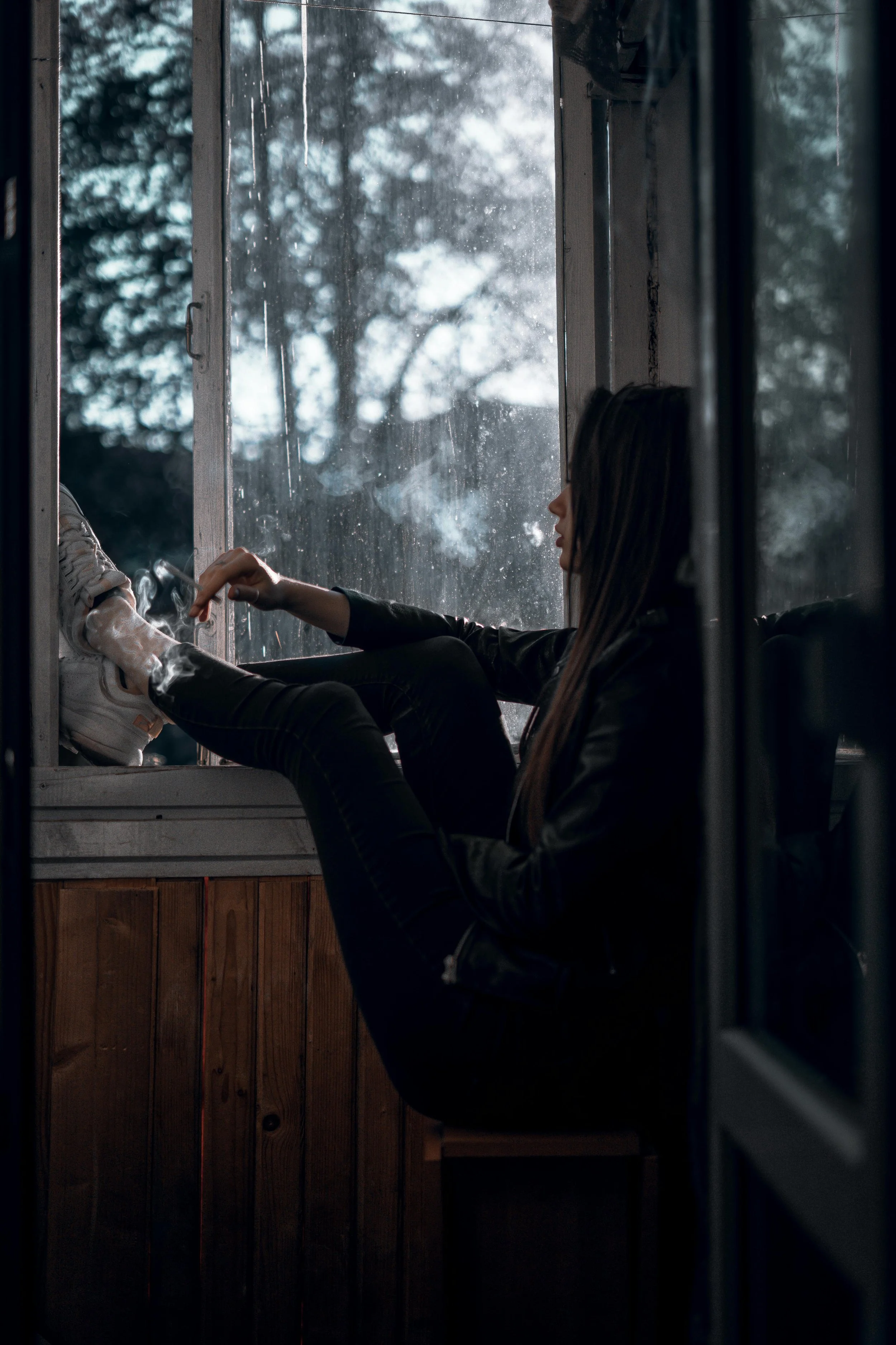 Woman looking thoughtfully out a window while reflecting on suppressed anger and anxiety