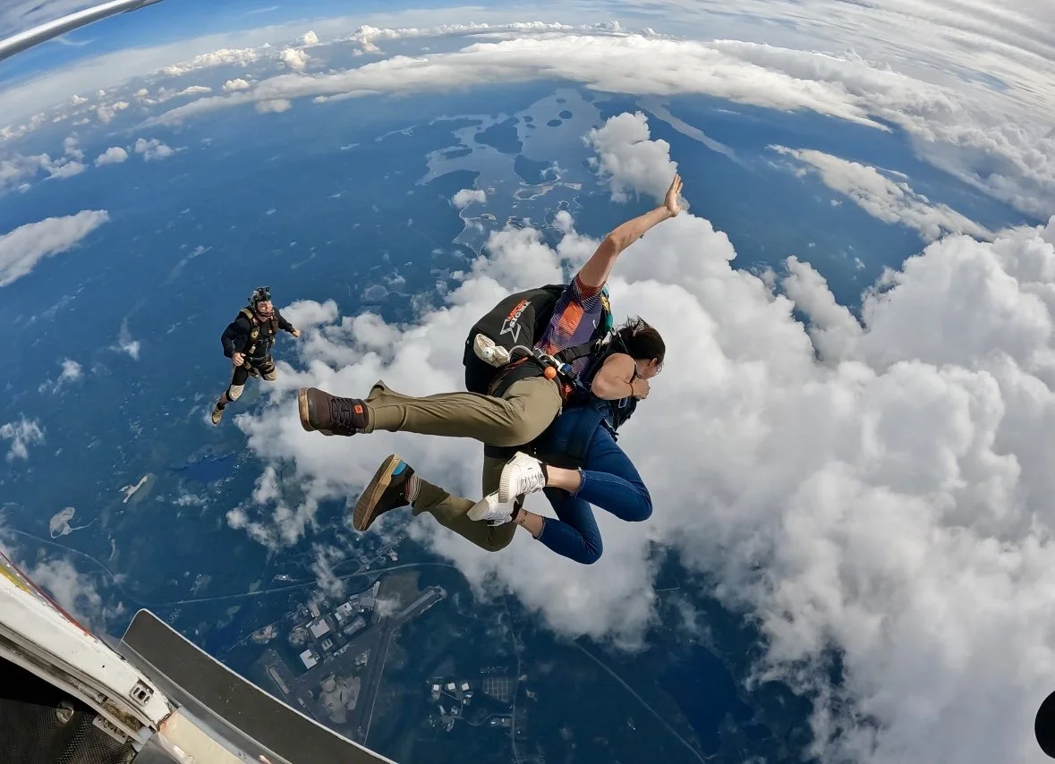 Lisa Kern tandem skydiving through the clouds after jumping from an airplane.