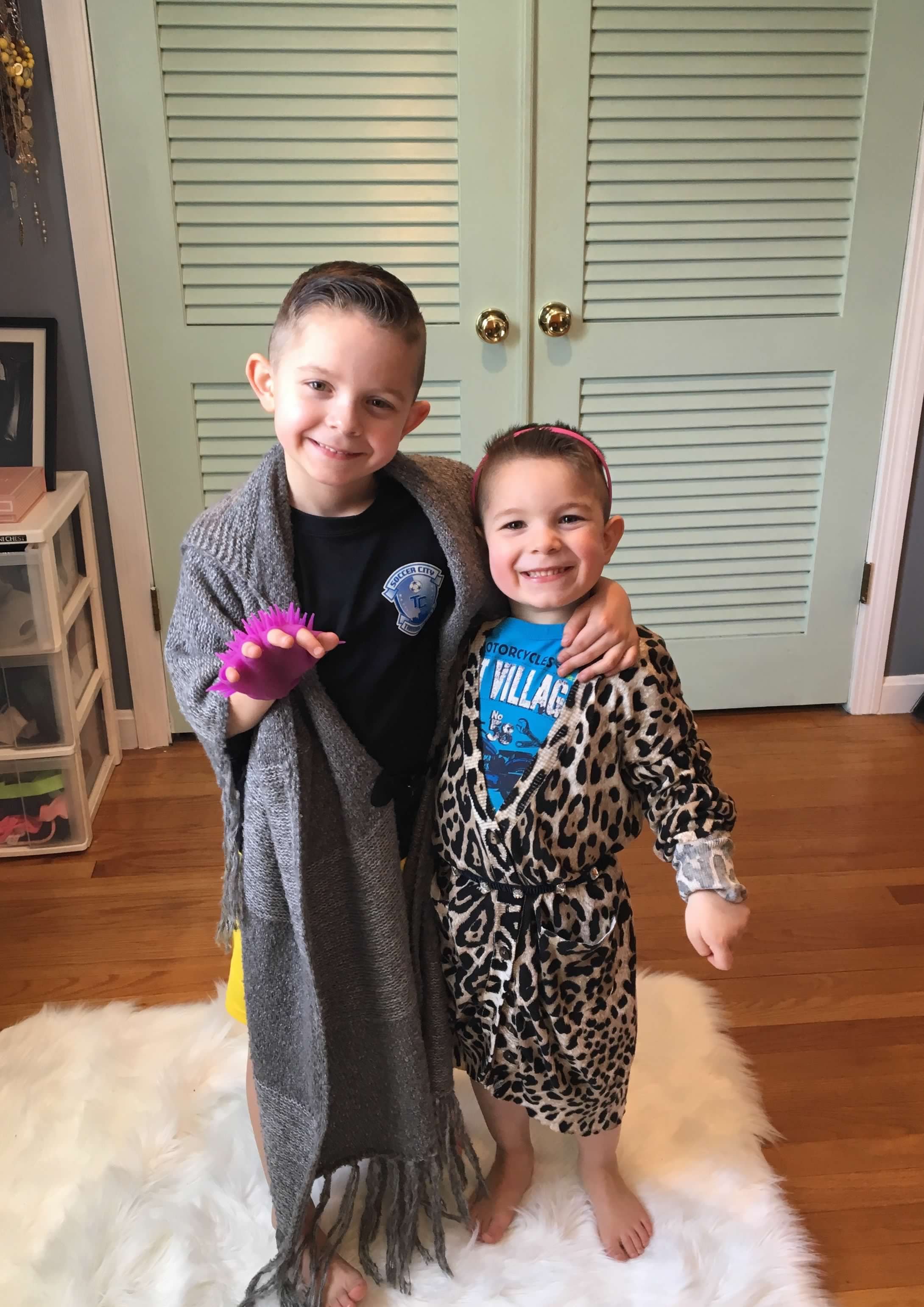 Two young brothers laughing and playing dress-up at home, embracing creativity and self-expression