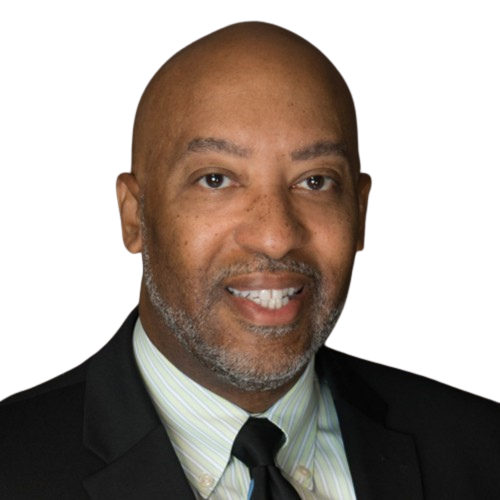 A portrait of a smiling African American man with a bald head, gray beard, dressed in a black suit, white shirt, and black tie.