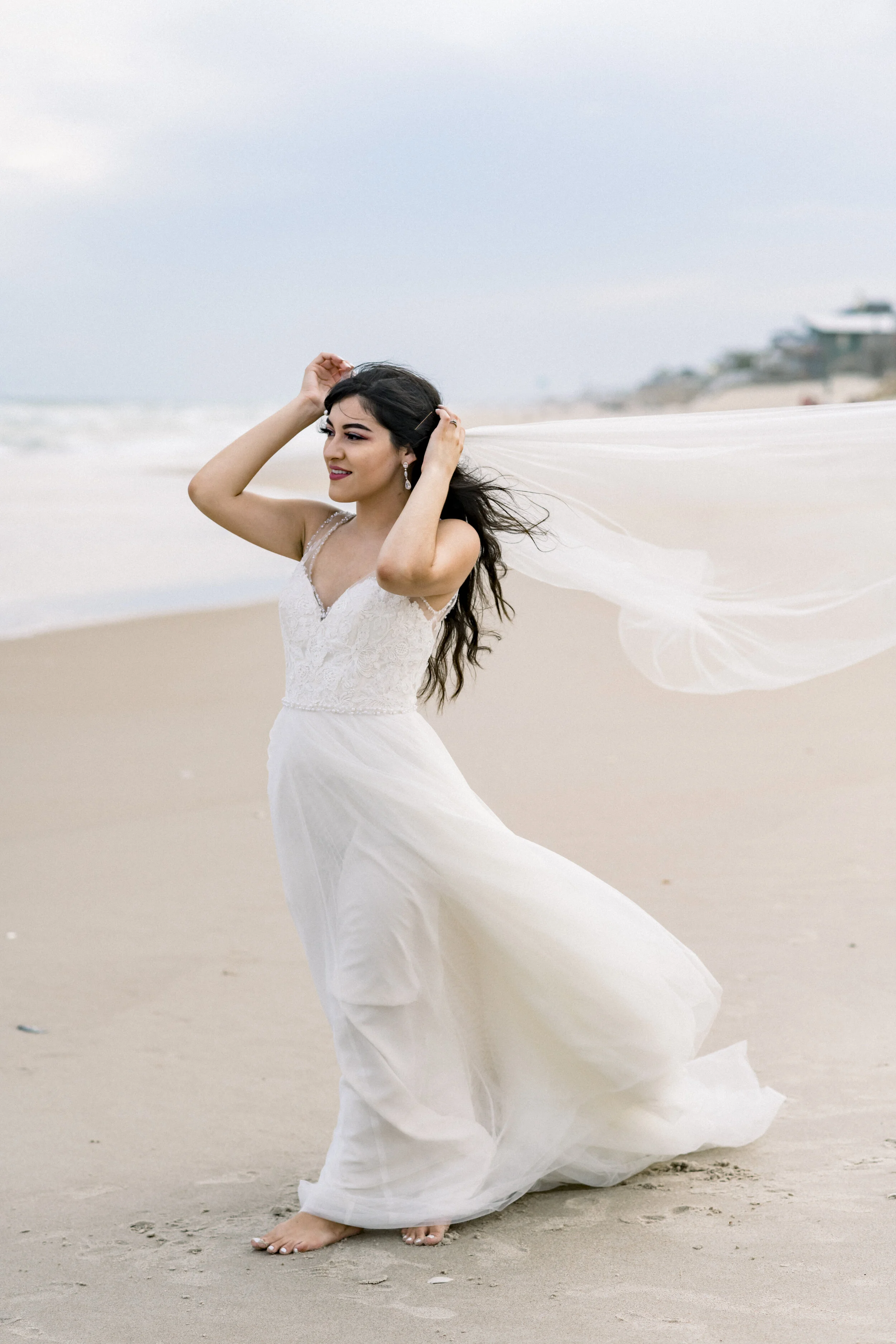 Bride on the beach fixing veil