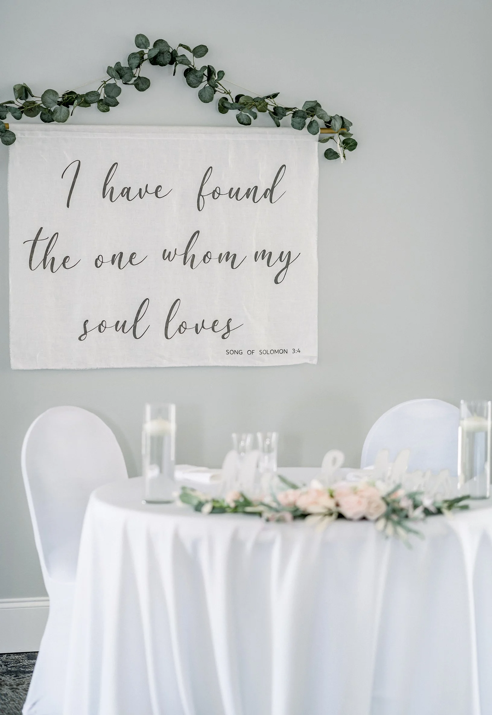 Song of Solomon banner behind Wedding couple's reception sweetheart table