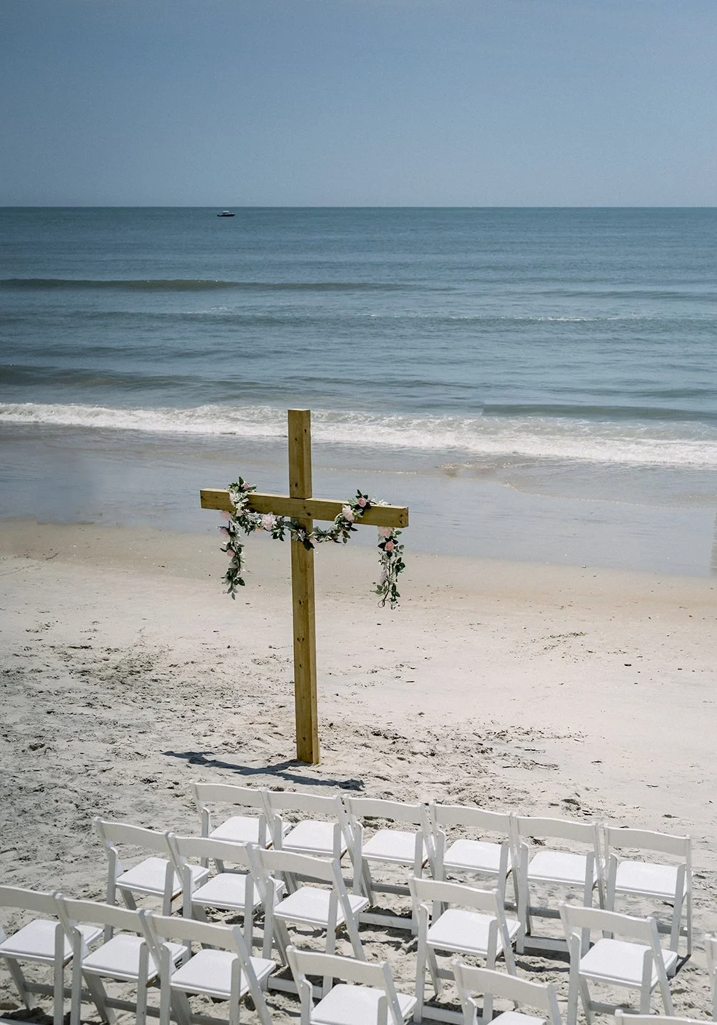 Beach Wedding Ceremony Set Up with chairs cross flowers and arbor