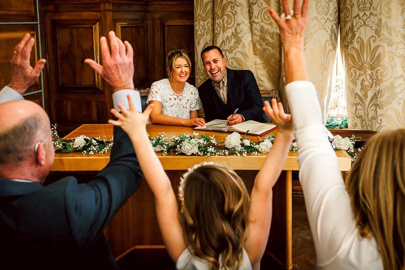 Newly wed bride and groom sign their marriage certificate in front of family and friends on their wedding day at Sale Town Hall