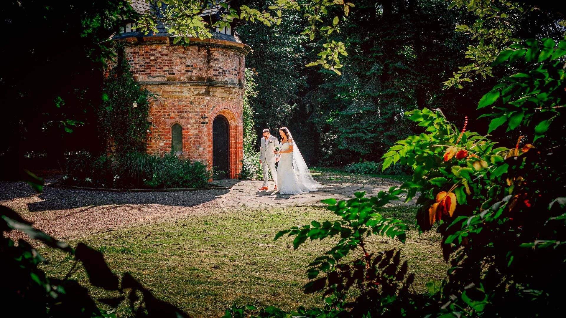 Beautiful moment as Joanna and Phil enjoy a walk by themselves following their wedding ceremony at Walkden Gardens in Sale, Greater Manchester on a beautiful summers day.