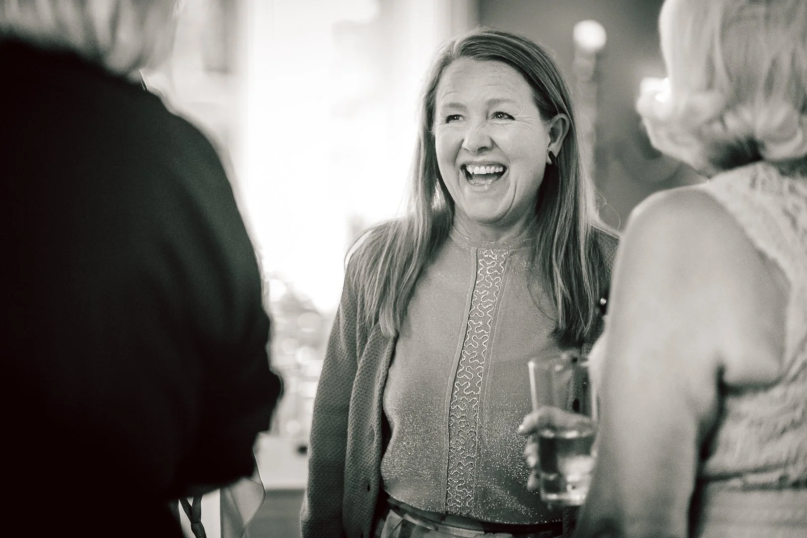 guest laughing during a conversation in the Blue Room at Didsbury House Hotel during the wedding reception