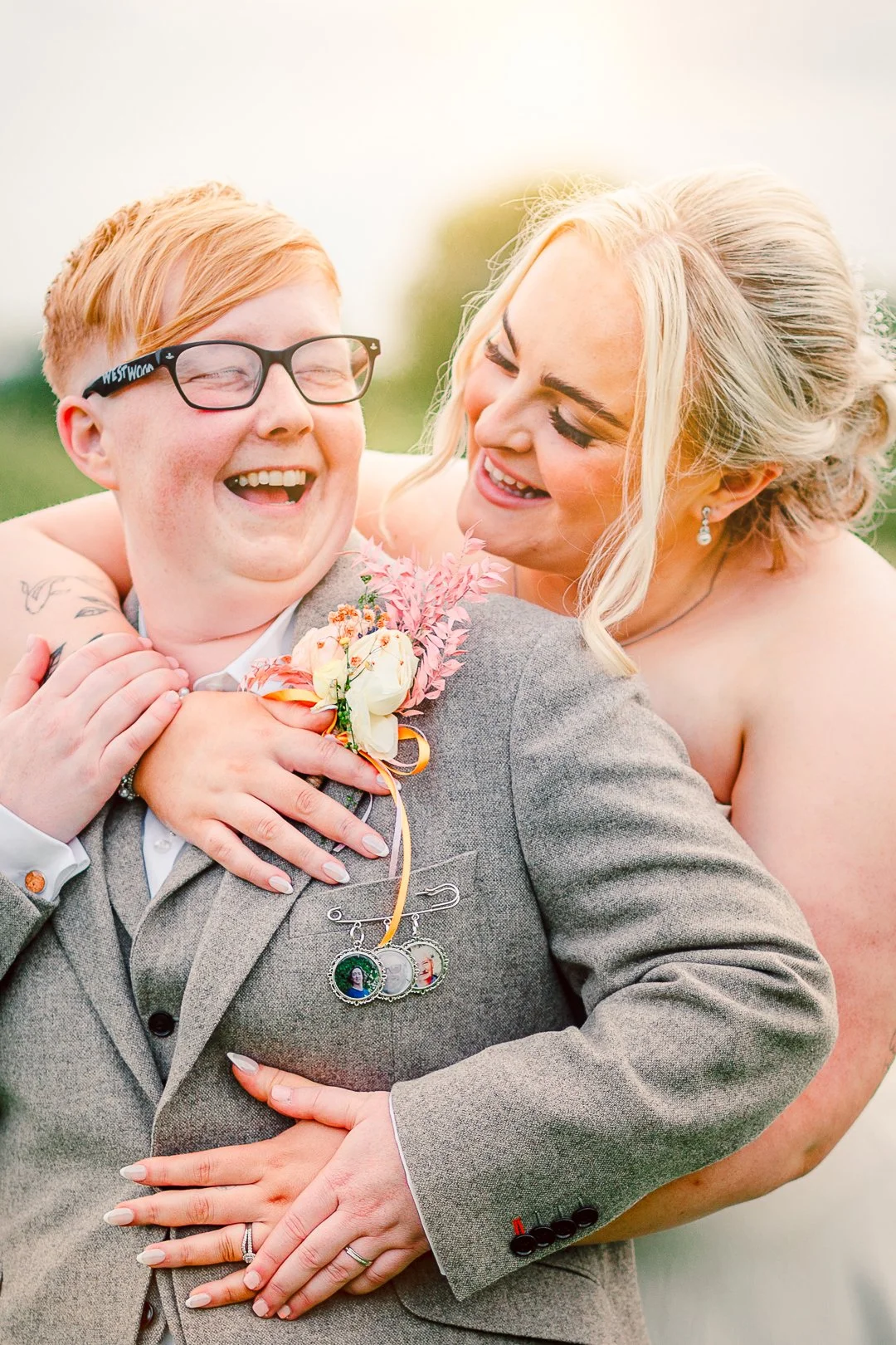 Natural, joyful moment of Mia embracing Rebecca from behind, captured at their wedding at Beeston Manor.