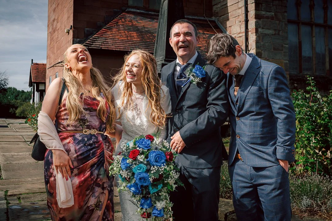Friends celebrate the joy of the wedding day laughing with each other outside the church